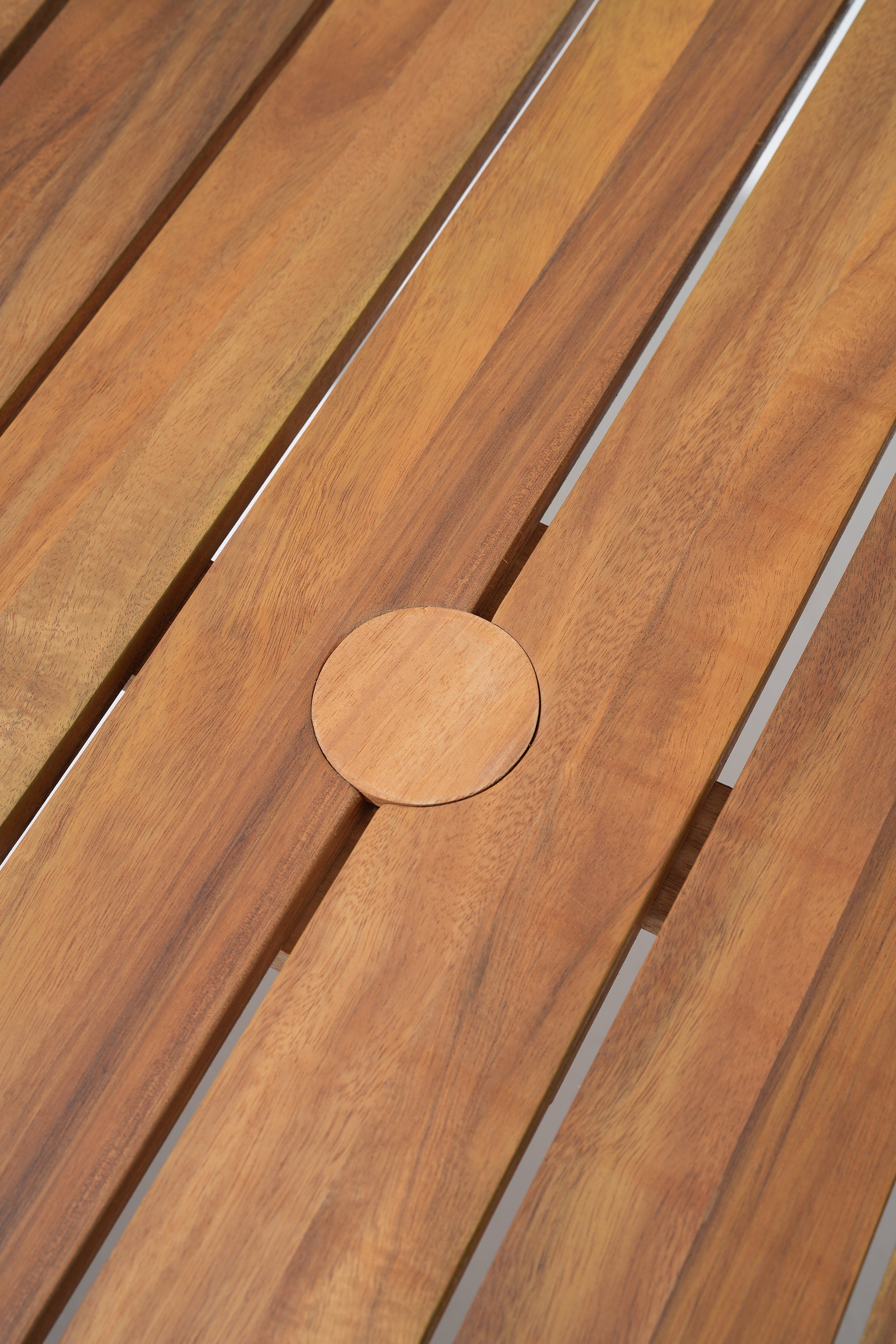 Close-up of acacia wooden slats table with a circular cutout