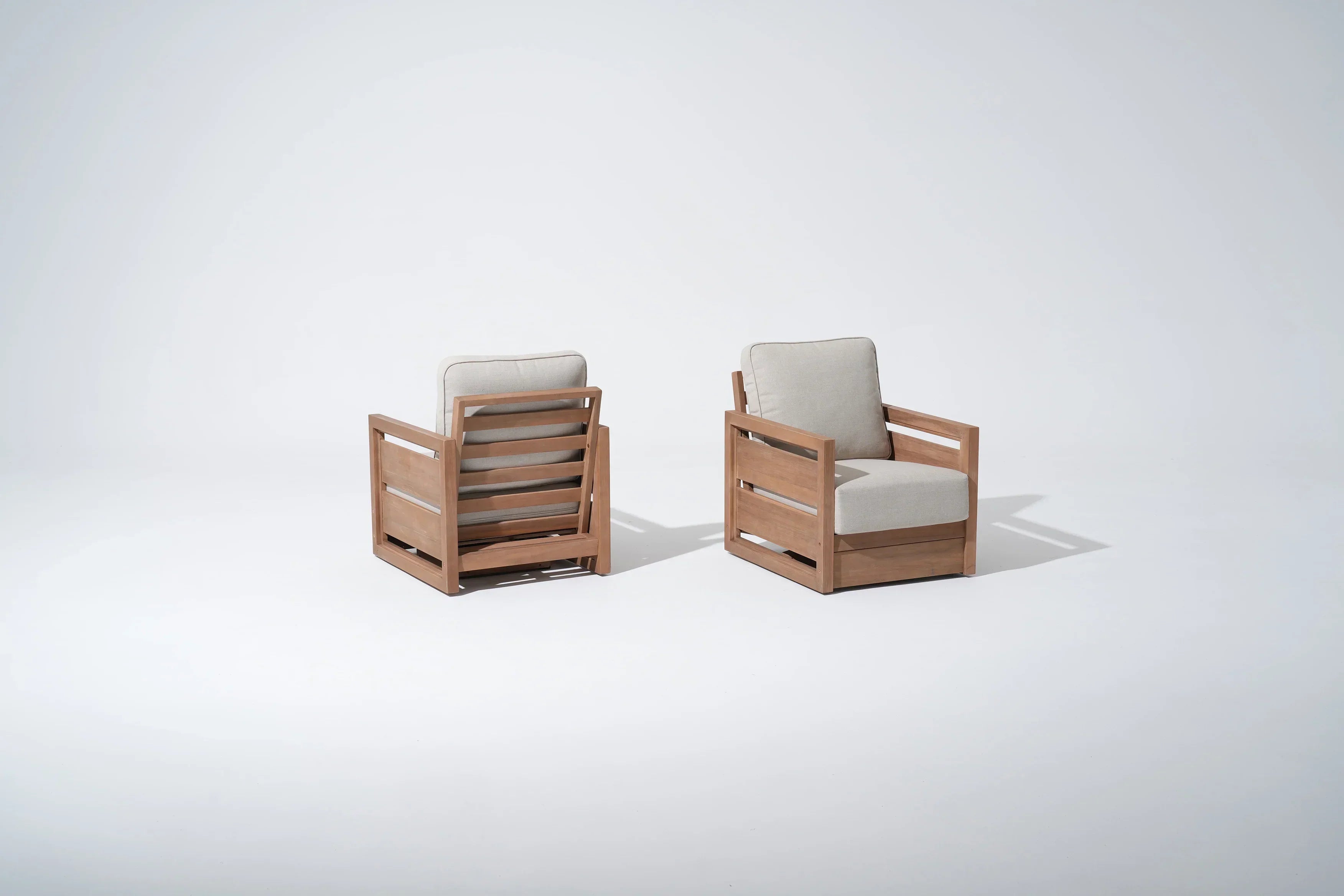 Two acacia wooden swivel chairs with beige cushions
