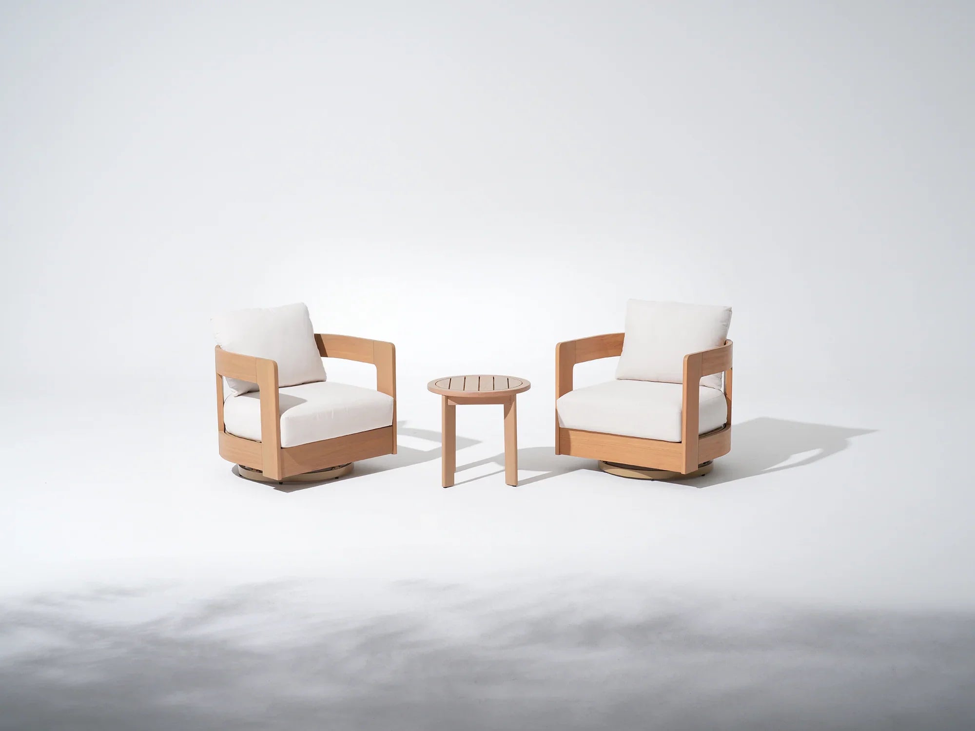 Two Eucalyptus wooden swivel chairs with white cushions and a small round coffee table