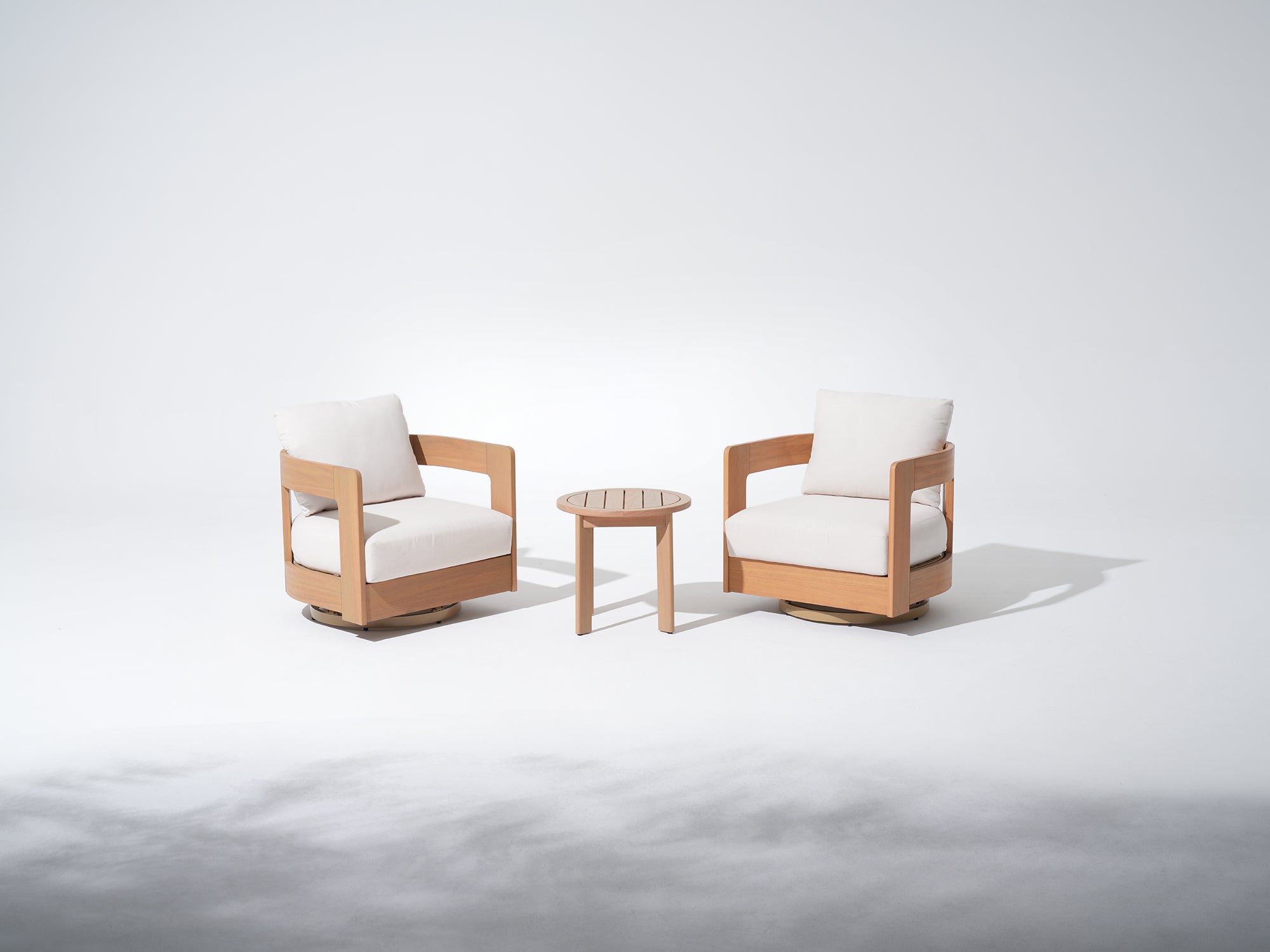 Two Eucalyptus wooden swivel chairs with white cushions and a small round coffee table