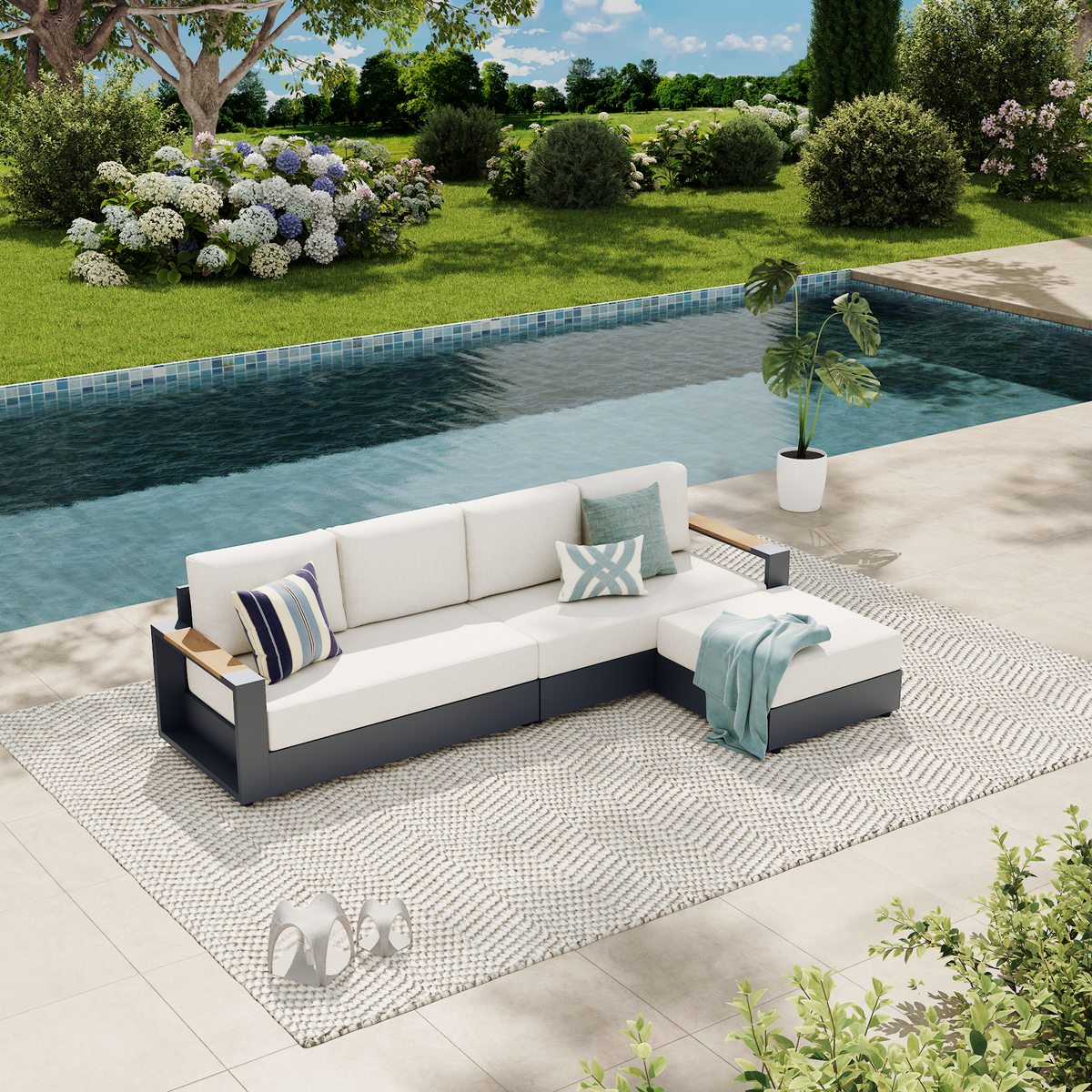 An outdoor sectional sofa with white cushions and a dark gray frame sits on a patterned rug beside a swimming pool in a landscaped backyard with green grass, shrubs, and trees. #config_4‑Seat Chaise
