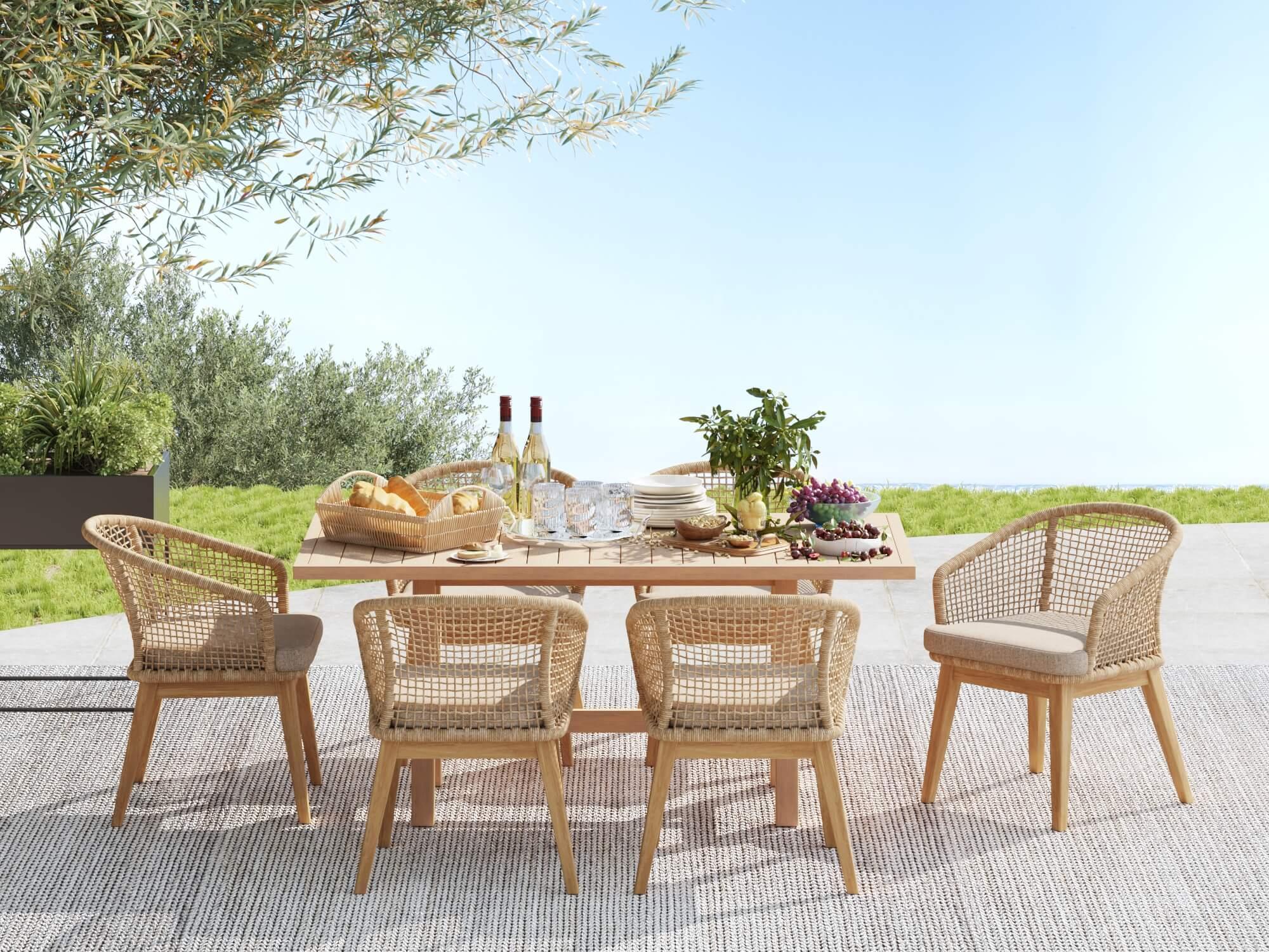 Noto acacia wood Outdoor dining table set for 6 with woven rope chairs on a patio, surrounded by greenery- Jardina Modern Premium Patio Outdoor Furniture
