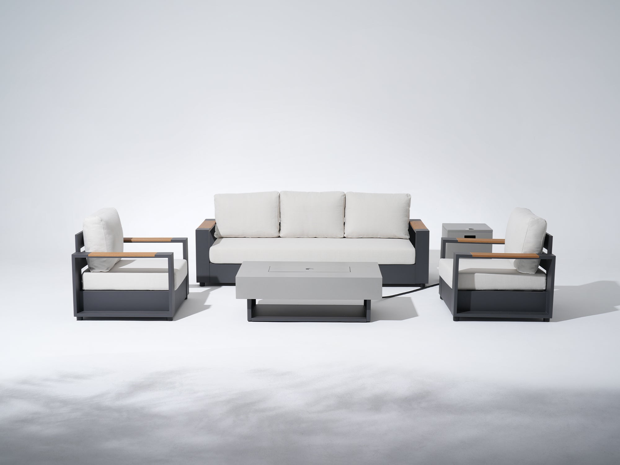 Modern outdoor furniture set with a sofa, chairs, and ottoman on a white background