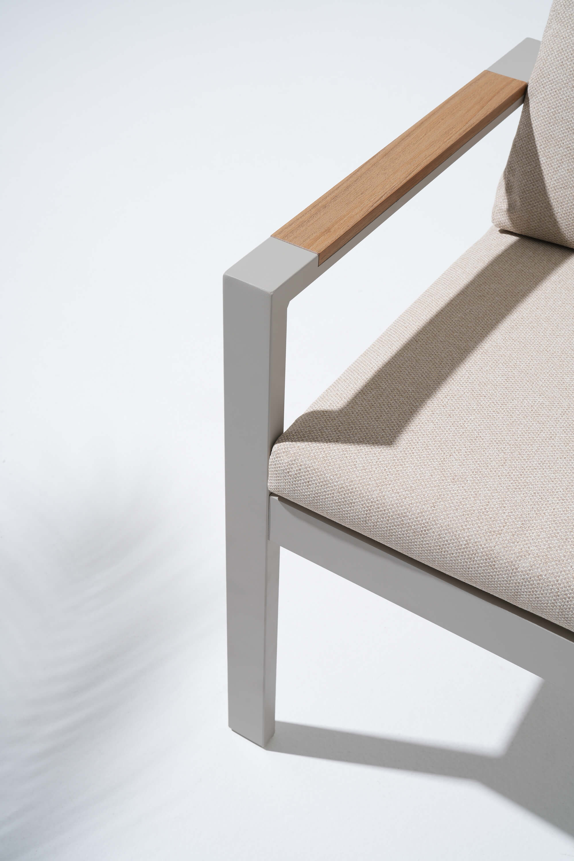 Chair with beige cushion and wooden armrest