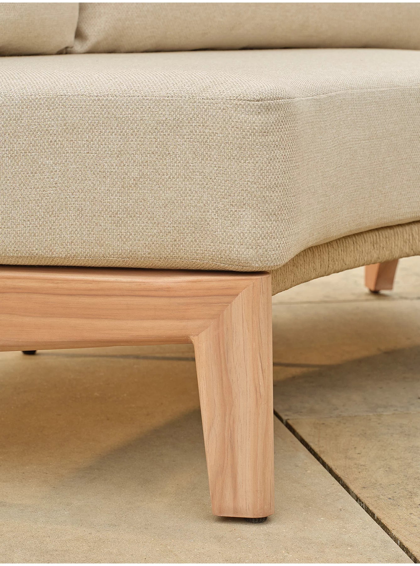 Close-up of a light beige upholstered sofa with a natural wood-look aluminum frame and leg- Jardina outdoor modern premium patio furniture