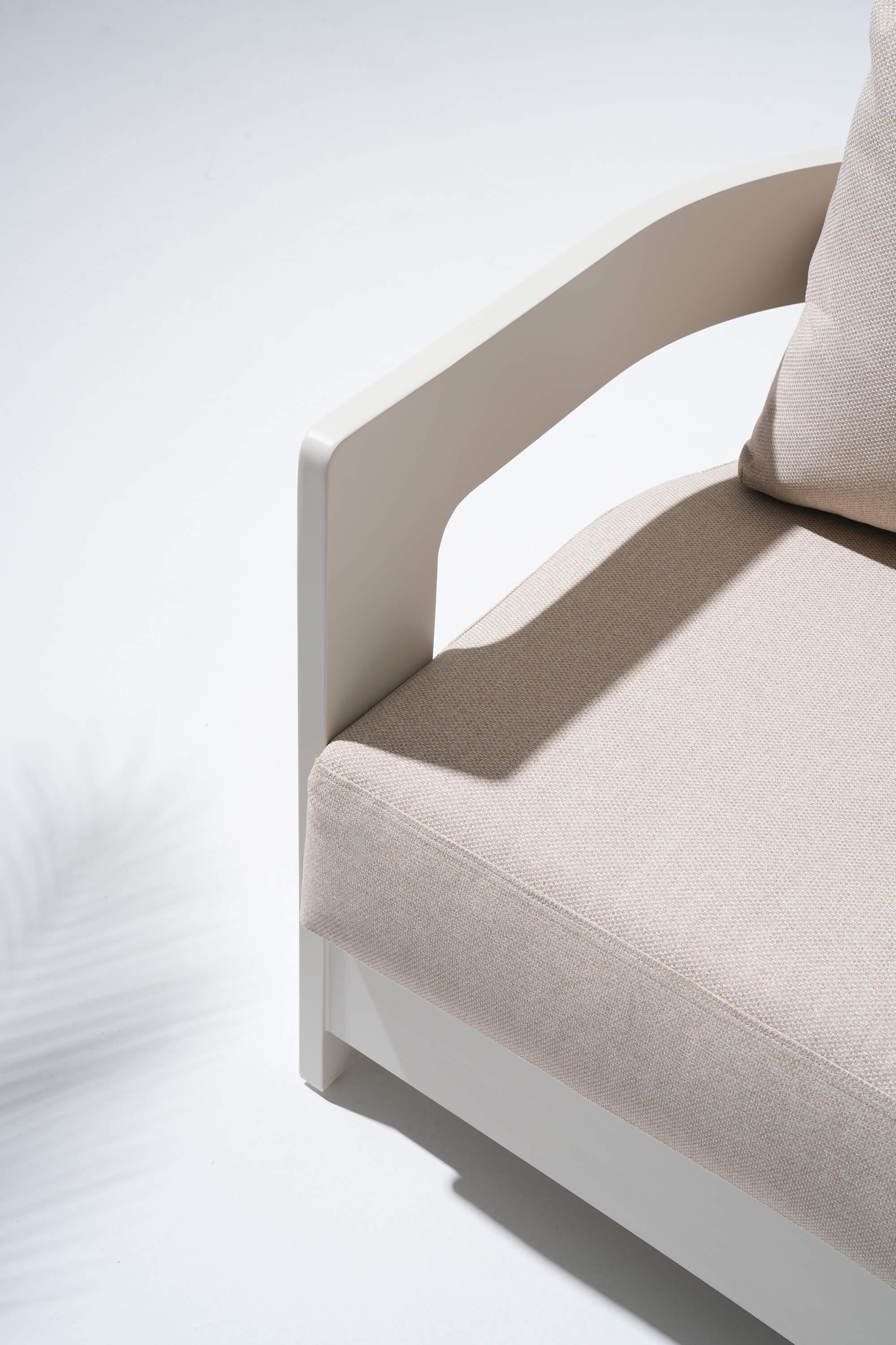Beige cushion on a white aluminum chair