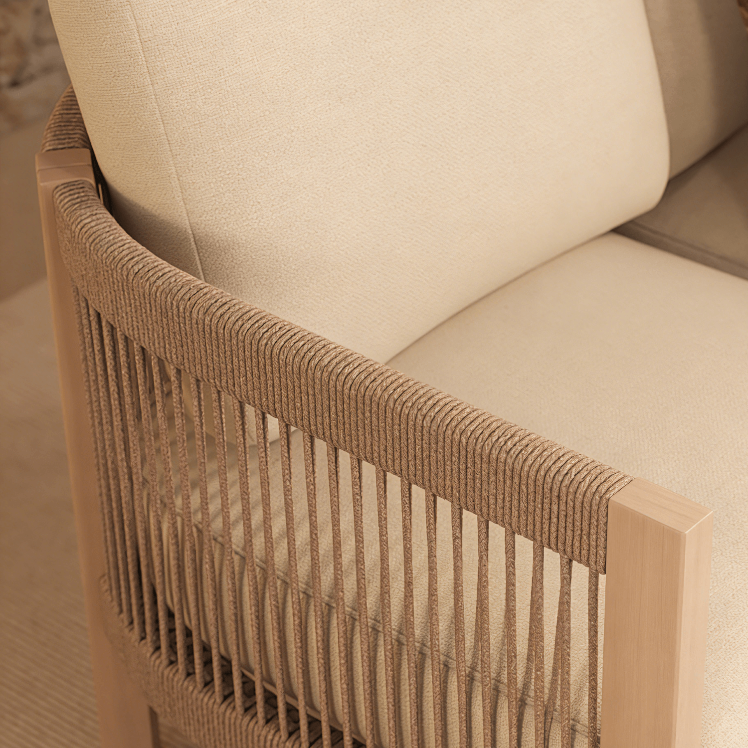 Close-up of a chair with woven rope armrest and beige cushion