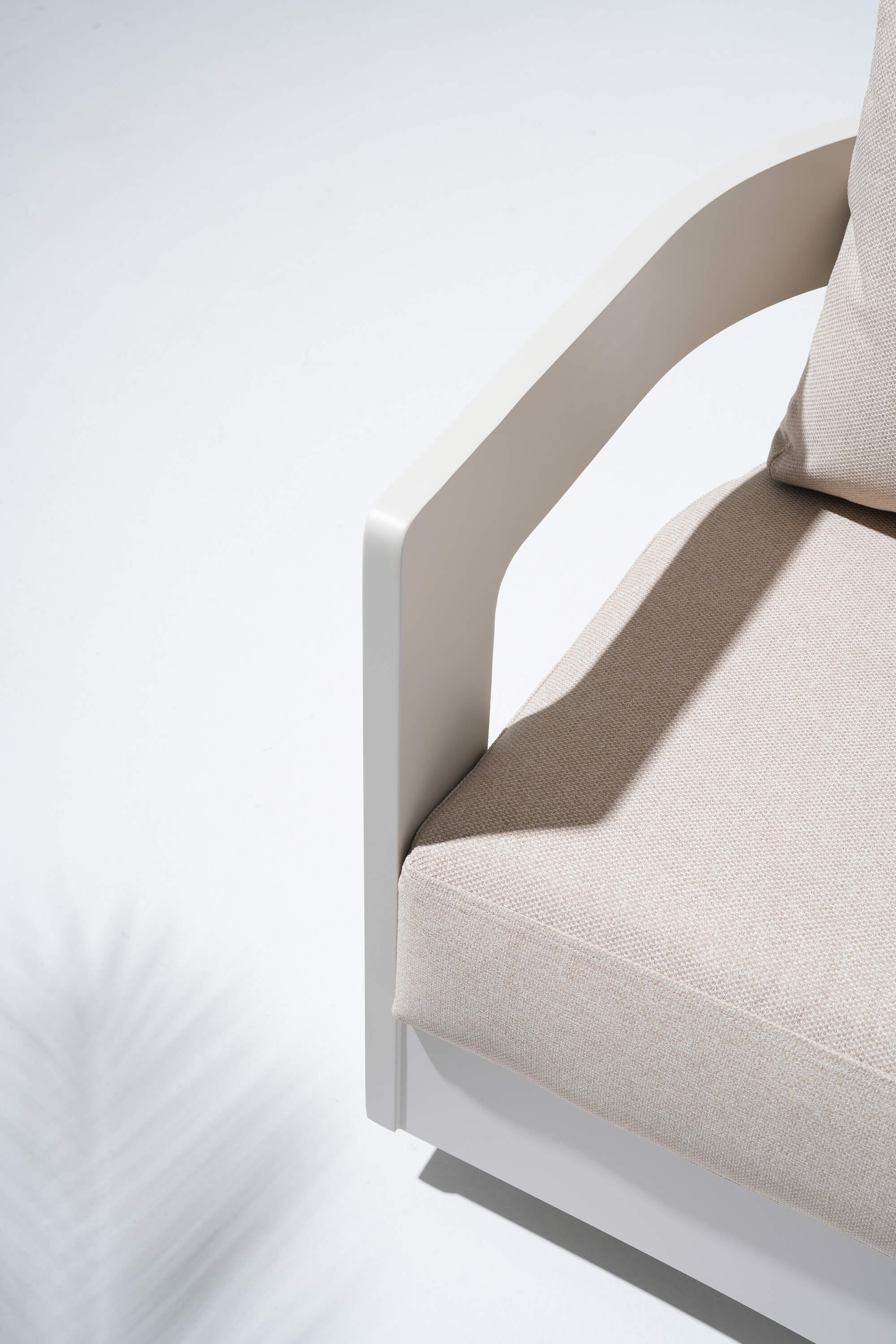 Close-up of a beige cushioned chair with a white frame on a light gray background #color_beige
