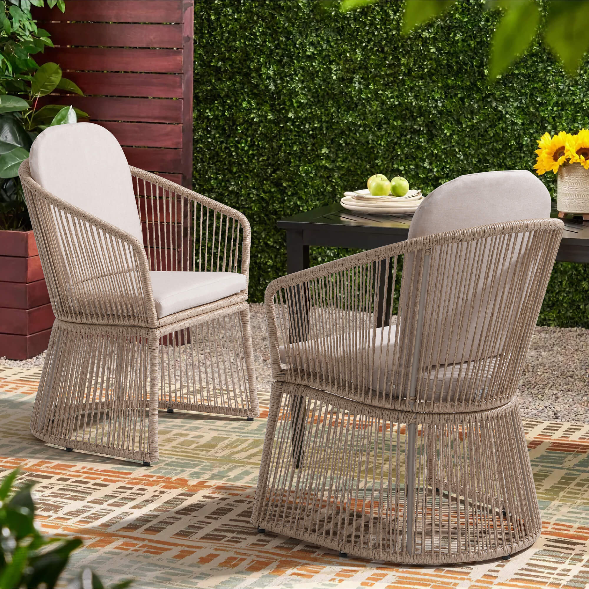 Two wicker swivel dining chairs with white cushions