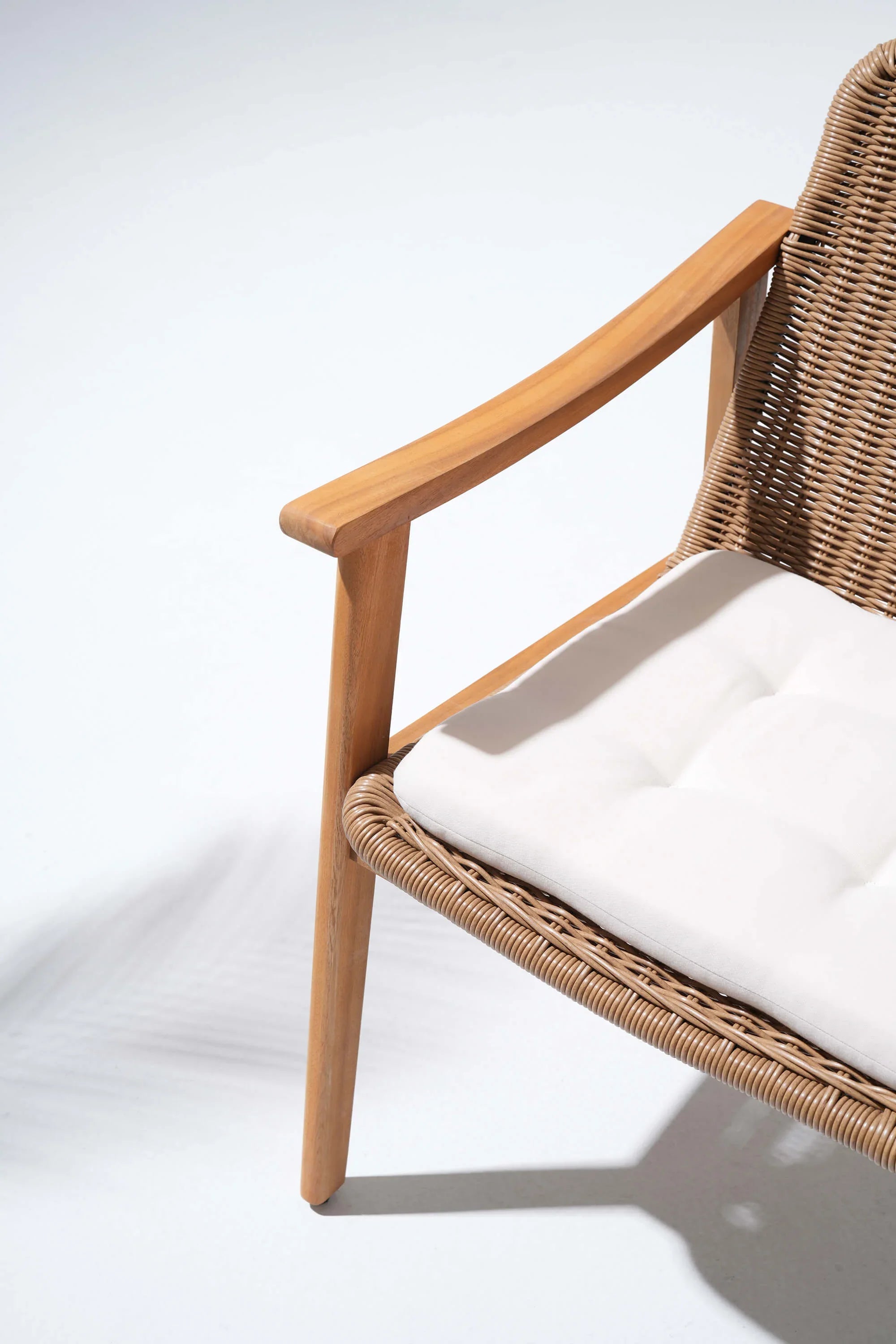 Wicker chair with acacia wooden armrests and white cushion