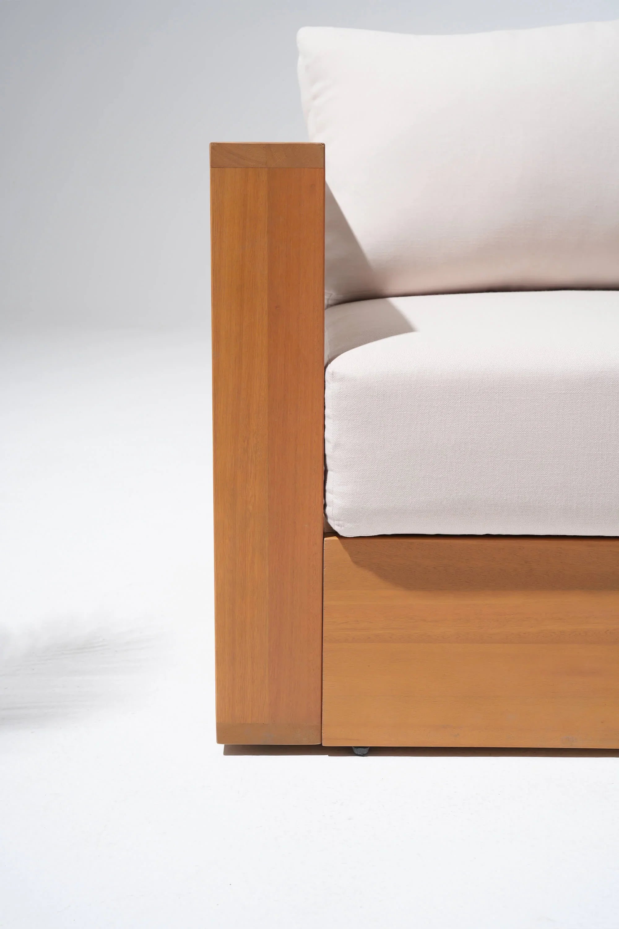 Section of a Eucalyptus wooden outdoor sofa with white cushions
