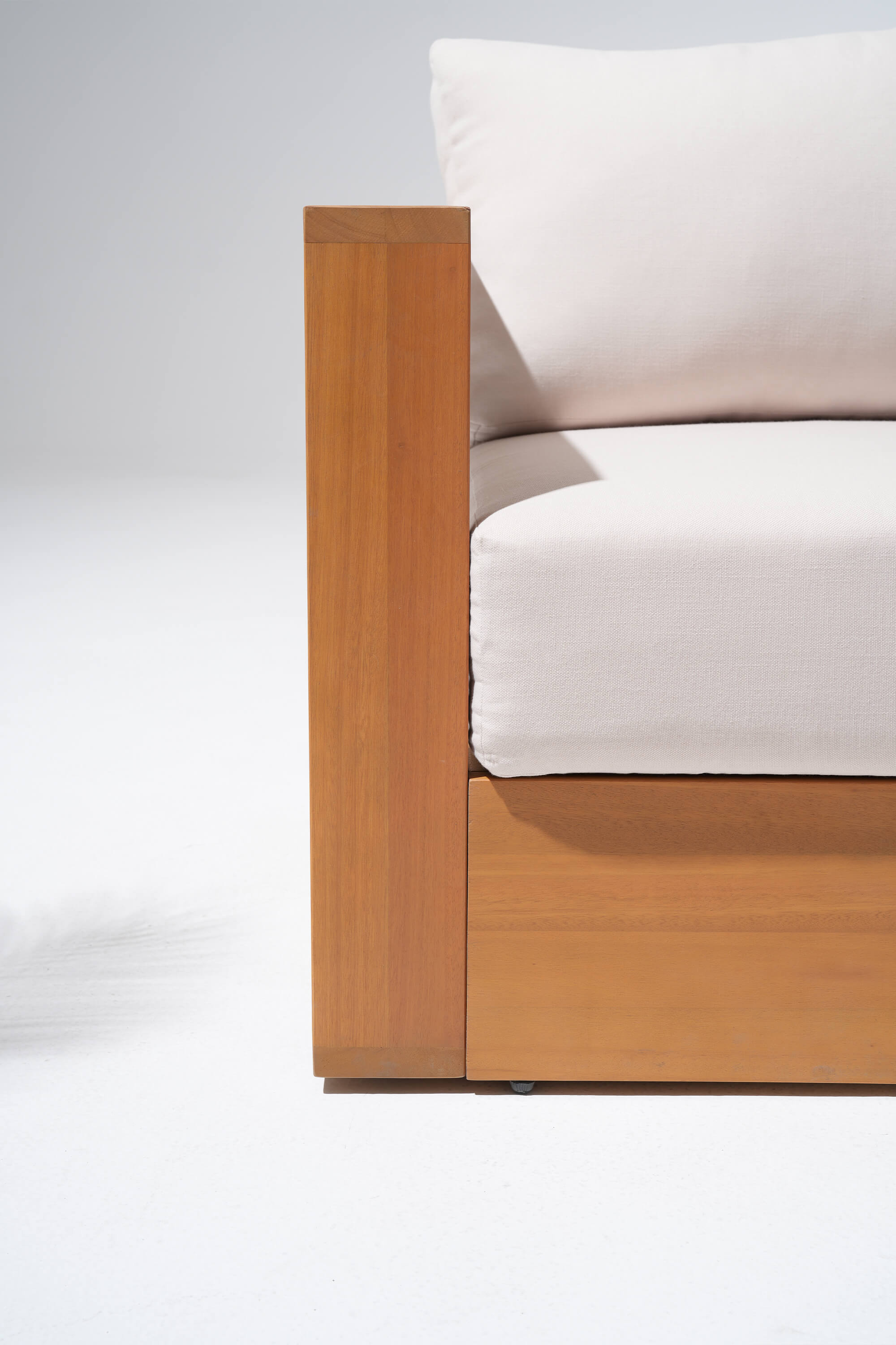 Section of a Eucalyptus wooden outdoor sofa with white cushions