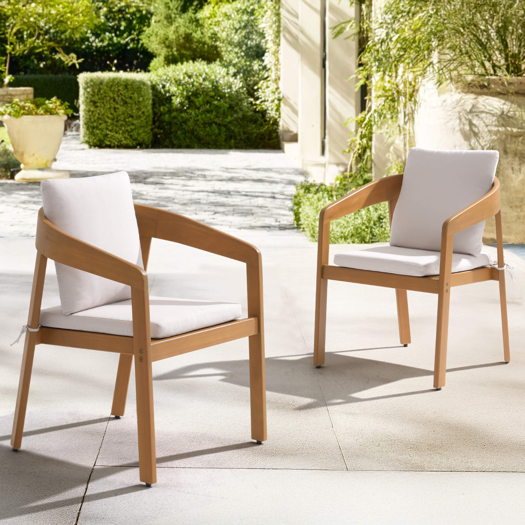 Two wooden chairs with white cushions on a patio - Jardina’s Modern Premium Outdoor Furniture