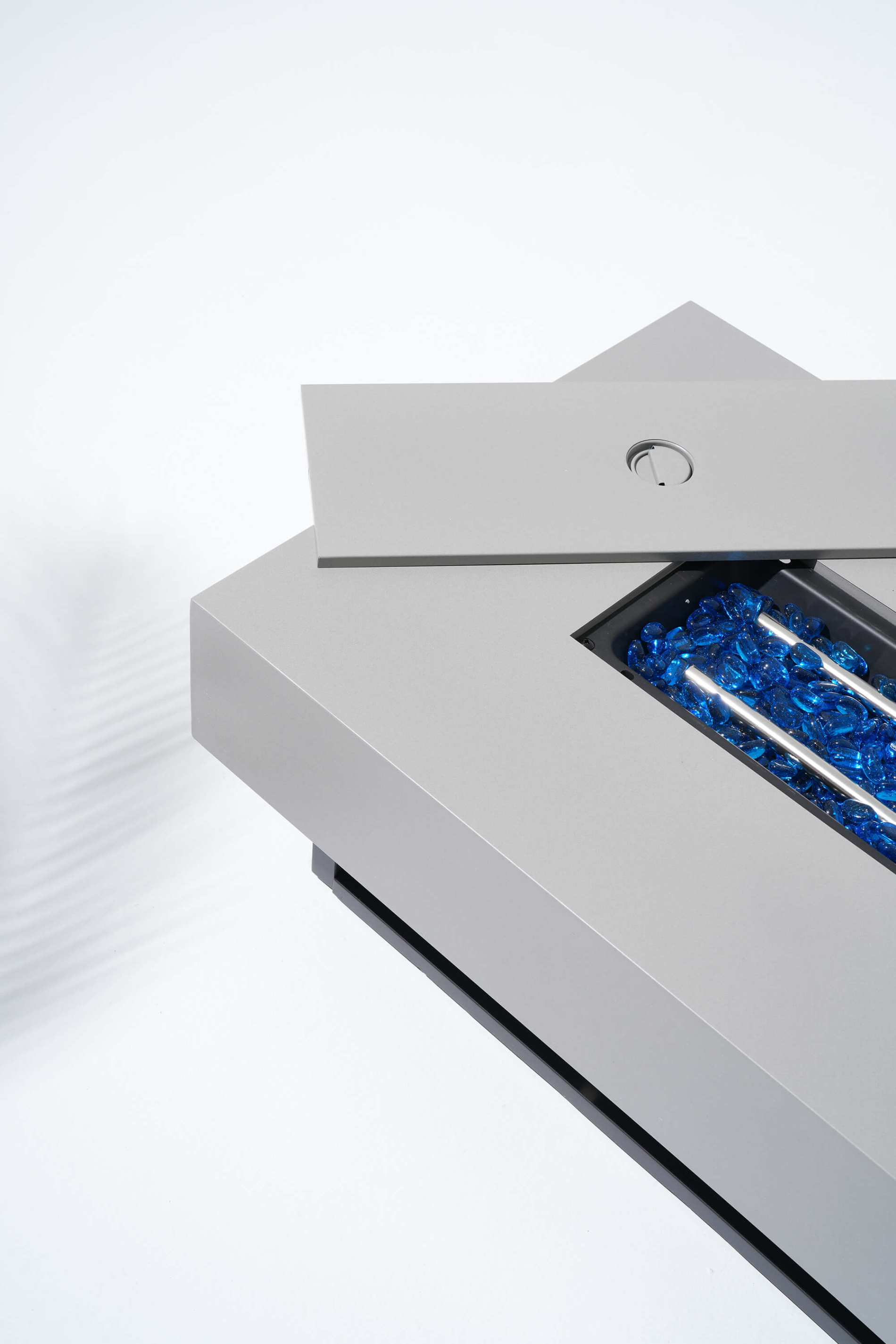 Stainless steel fire pit with blue flames on a white background