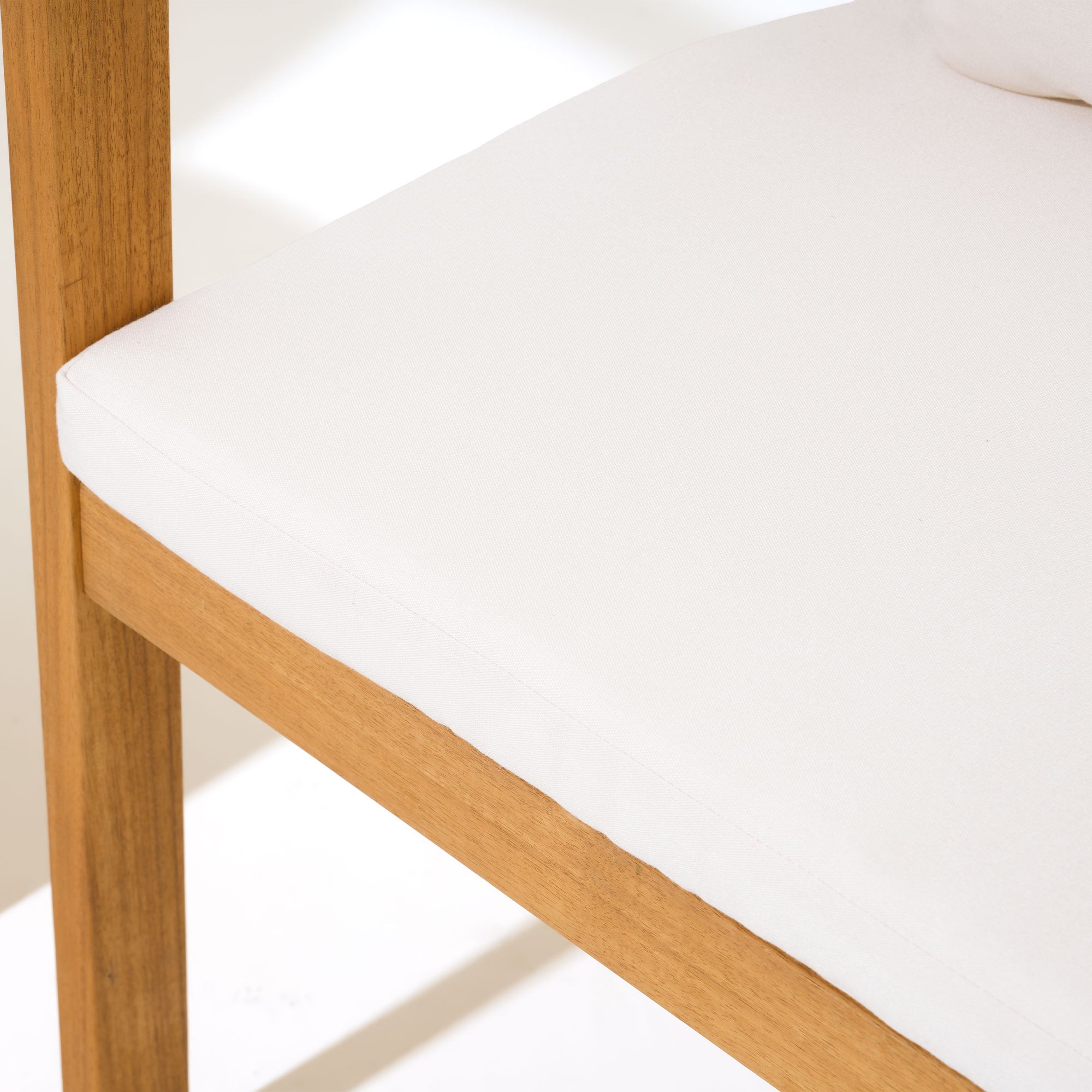 Close-up of a acacia wooden chair with a white cushion- Jardina Modern Premium Patio Outdoor Furniture