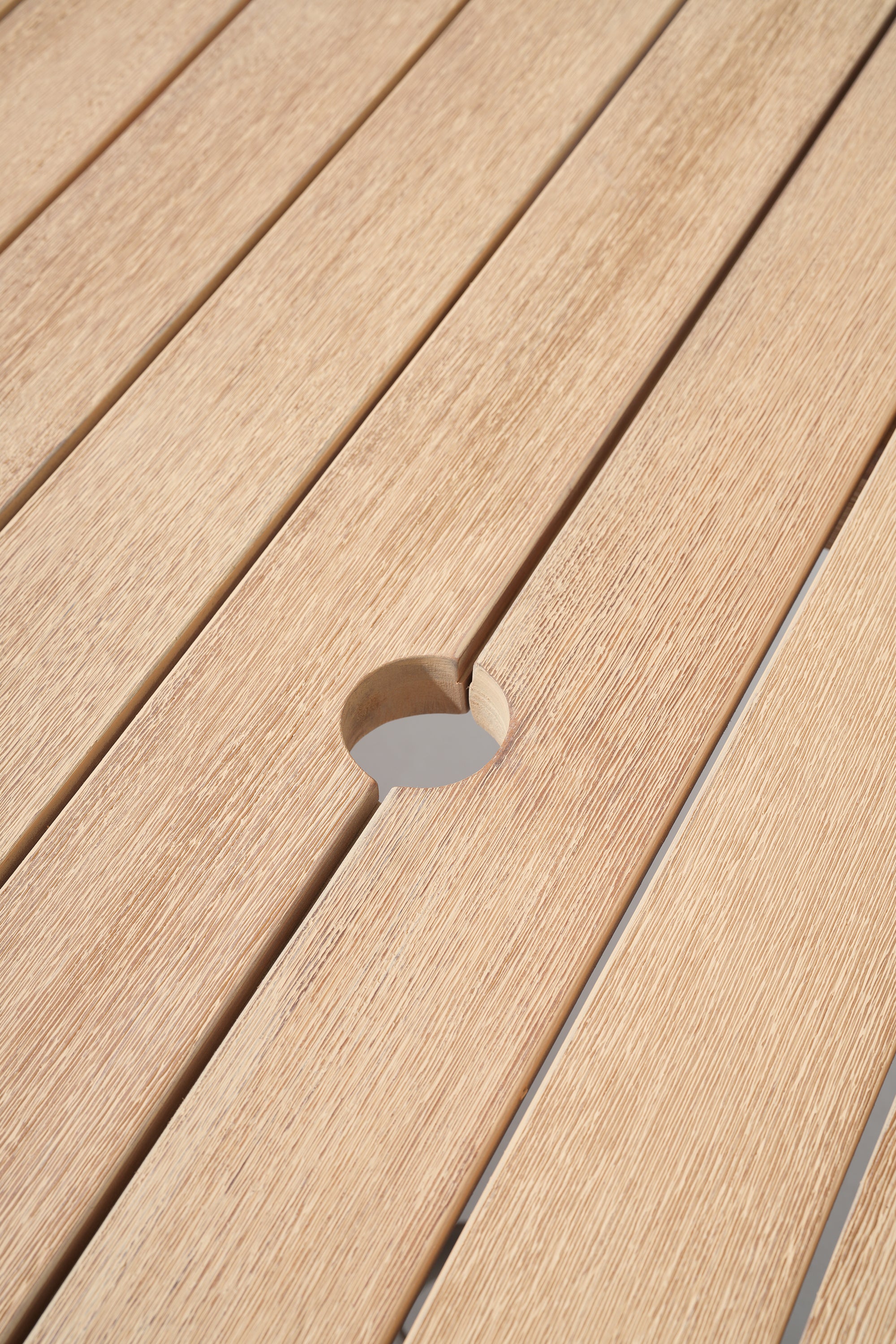 Close-up of a wooden deck with a circular hole.