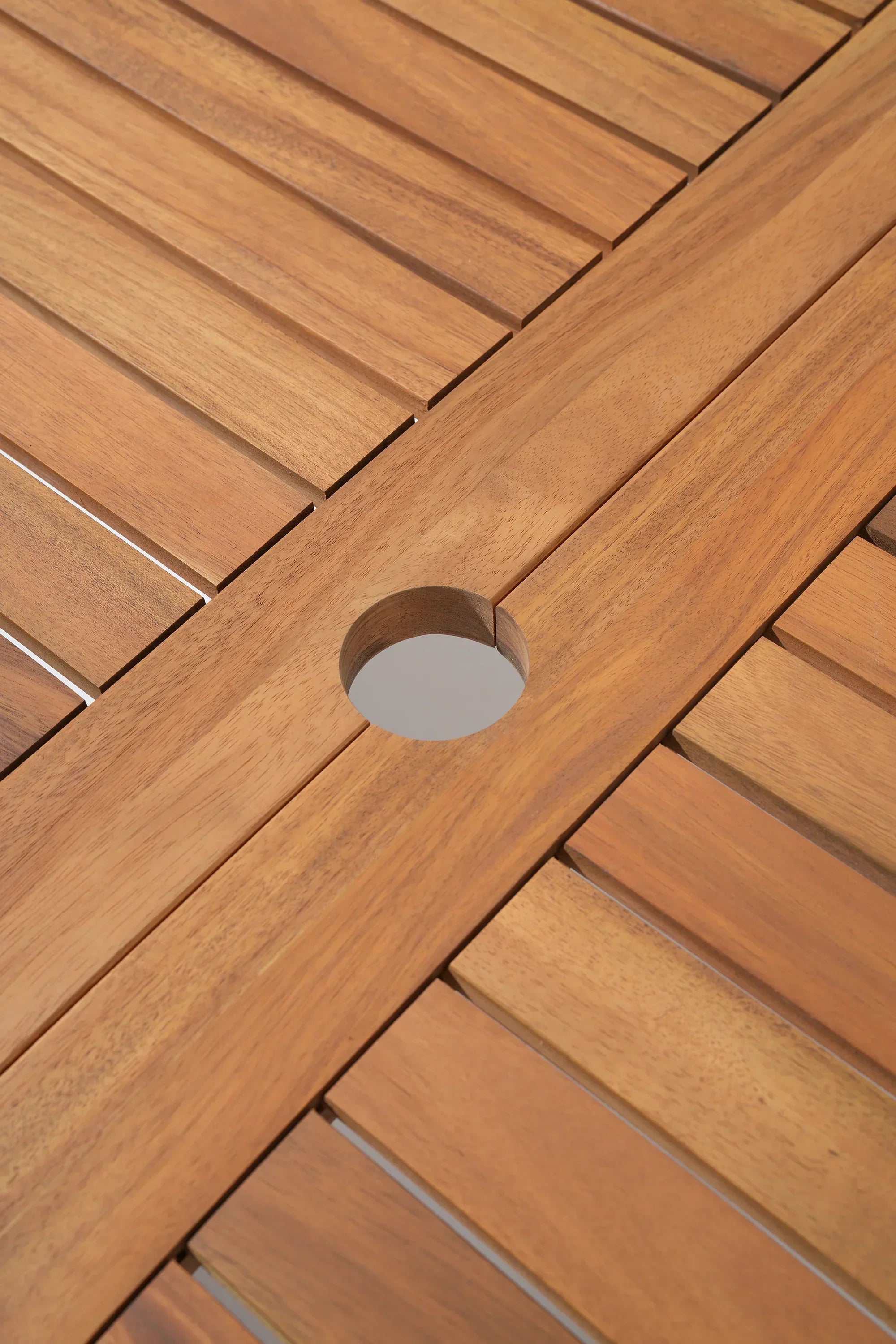Close-up of acacia wooden table with an umbrella hole