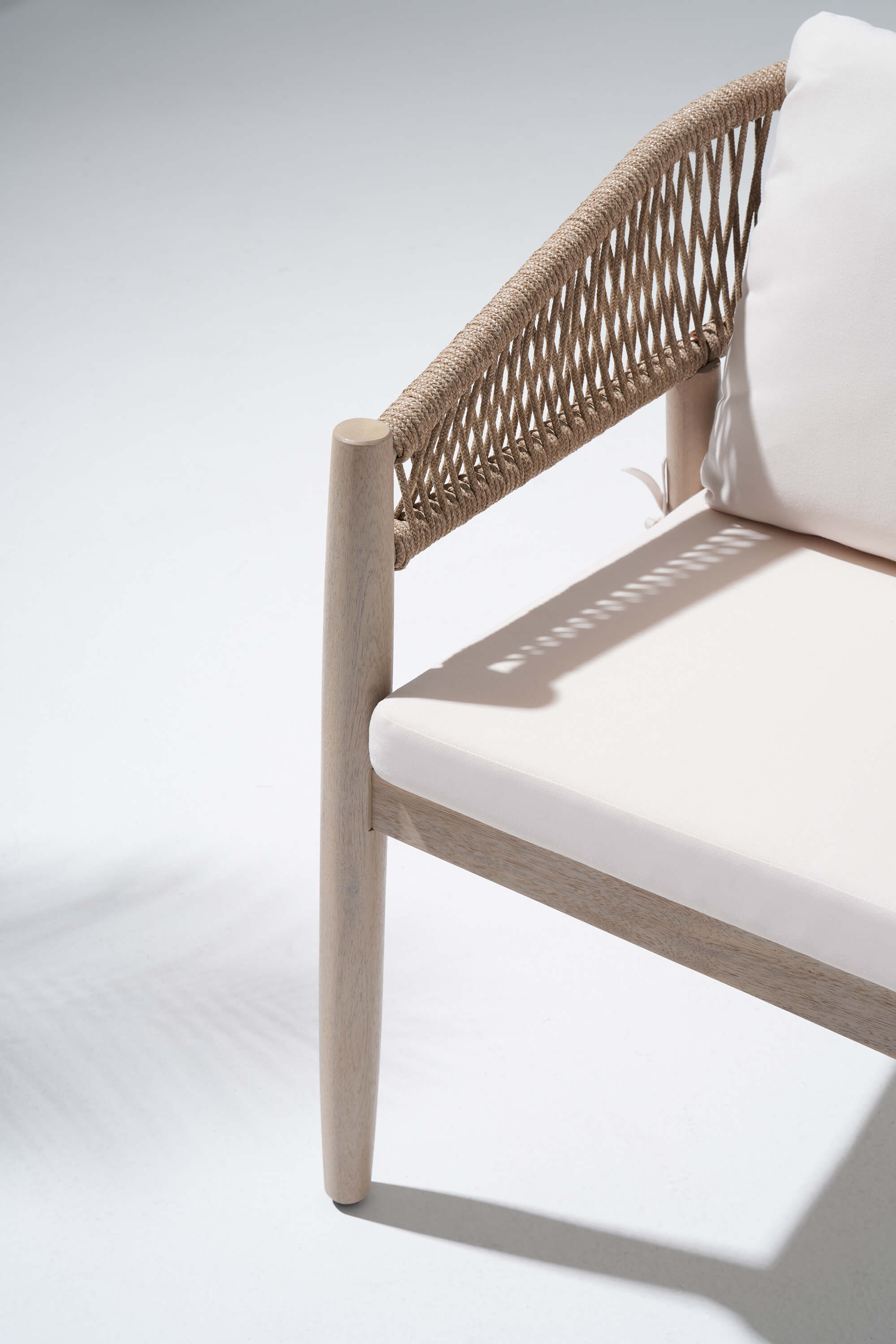 Chair with woven backrest and white cushion