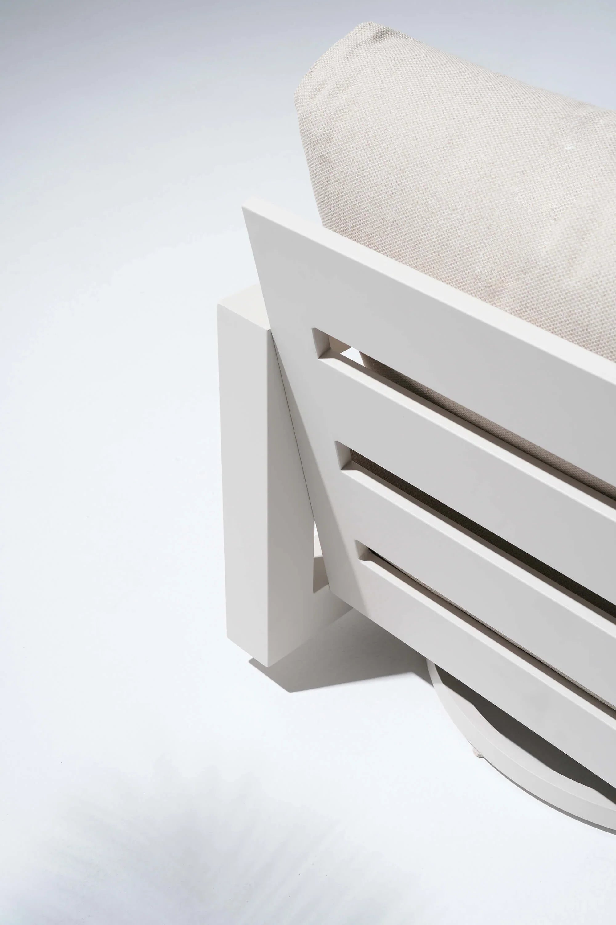 White outdoor chair with a beige cushion