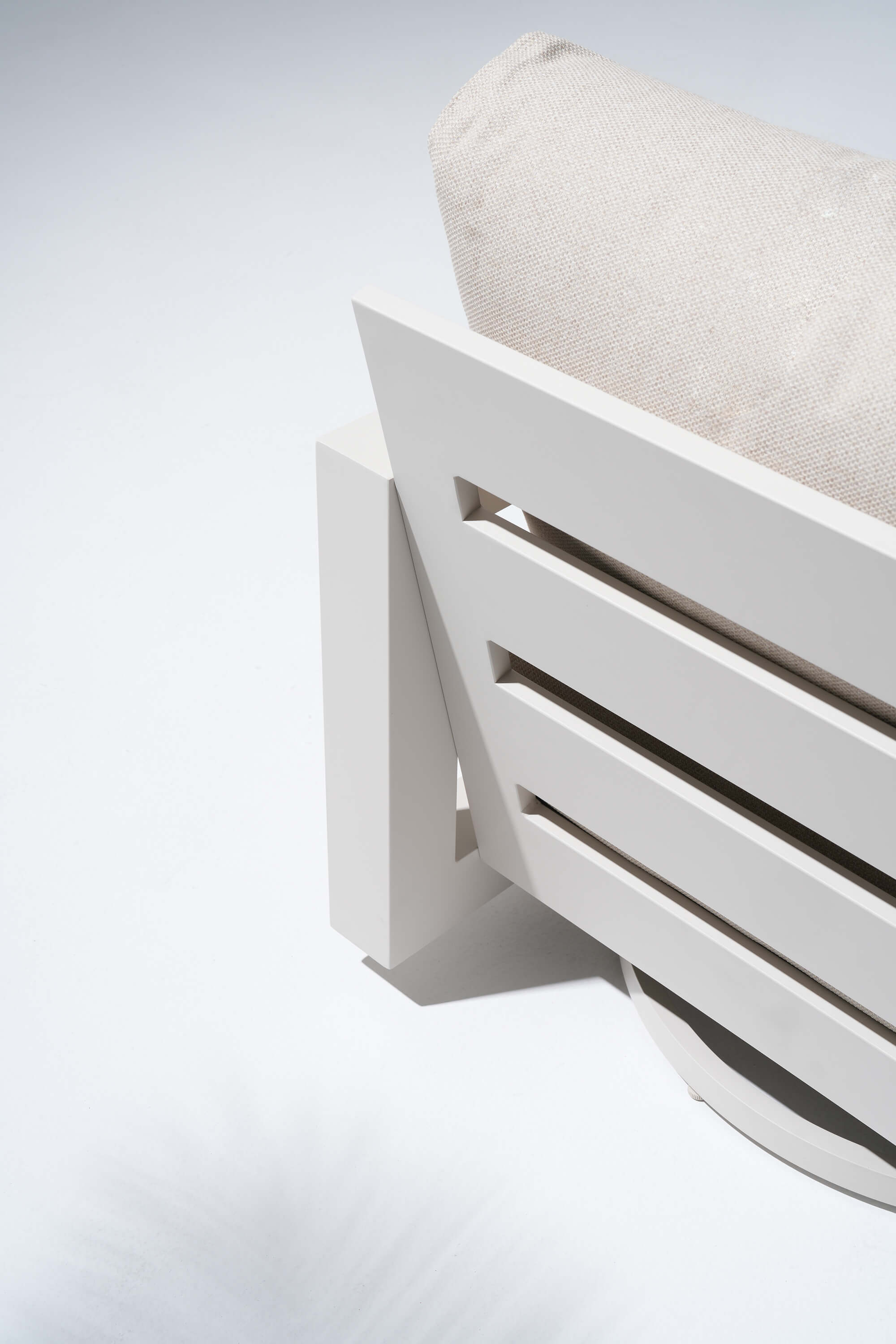 White outdoor chair with a beige cushion