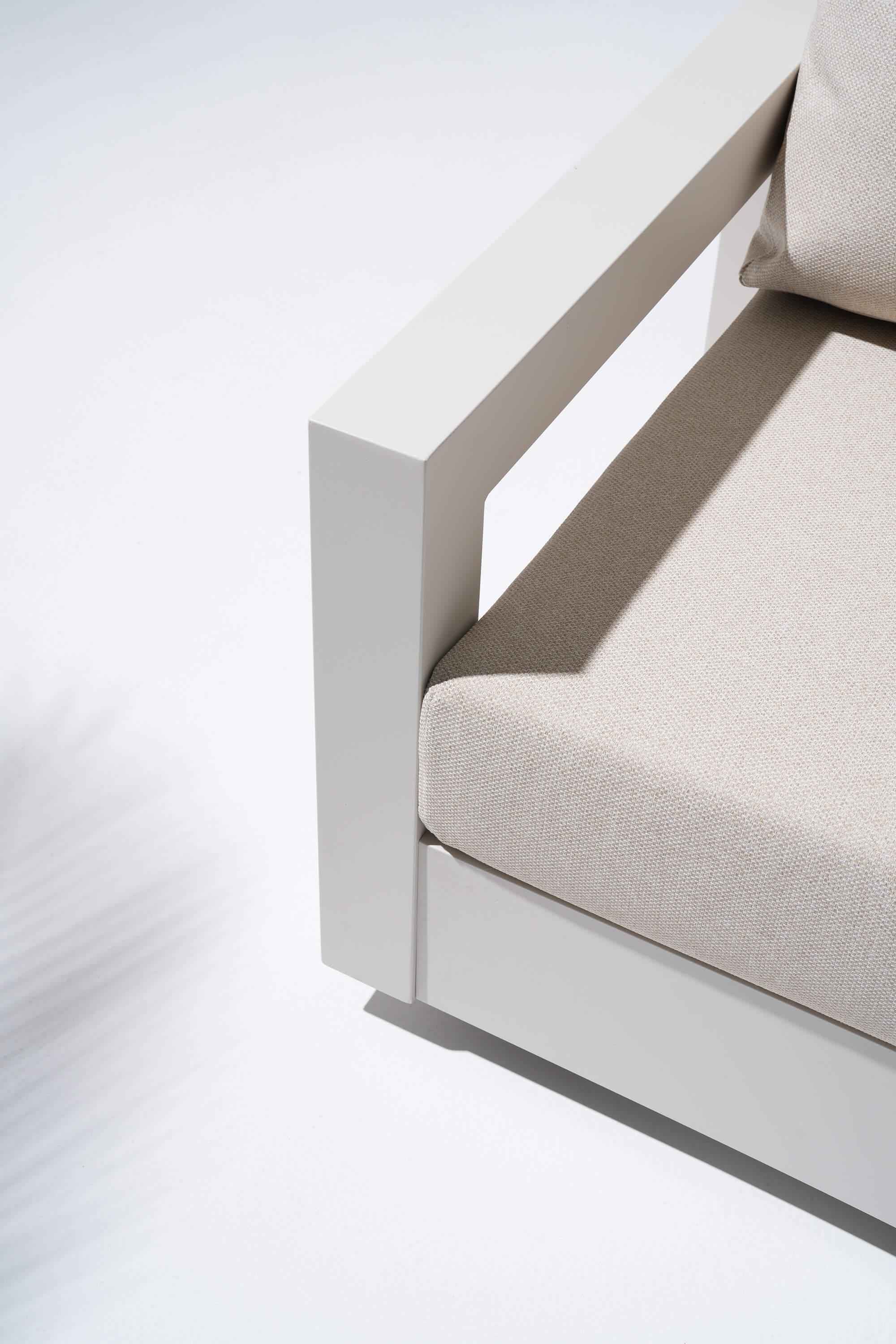 Corner of a modern outdoor sofa with beige cushions