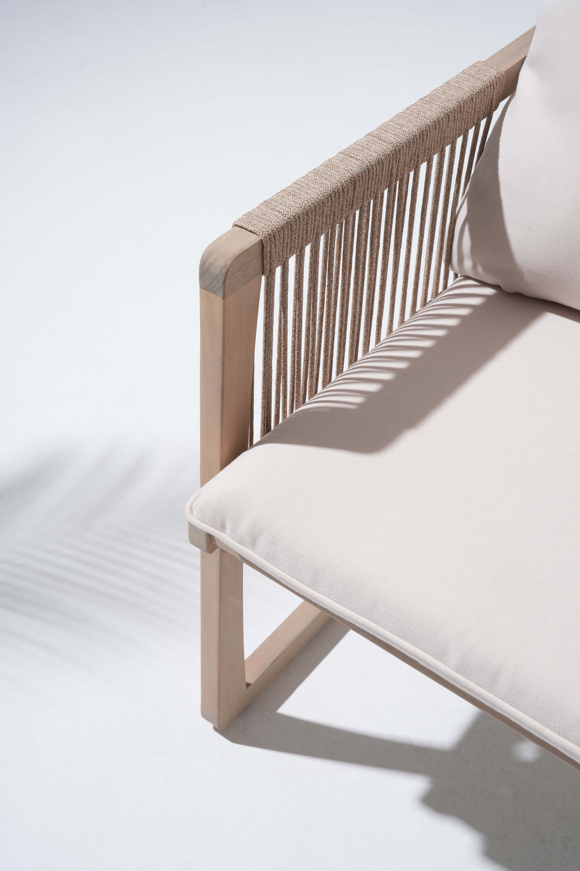 Beige outdoor acacia wood chair with white cushions