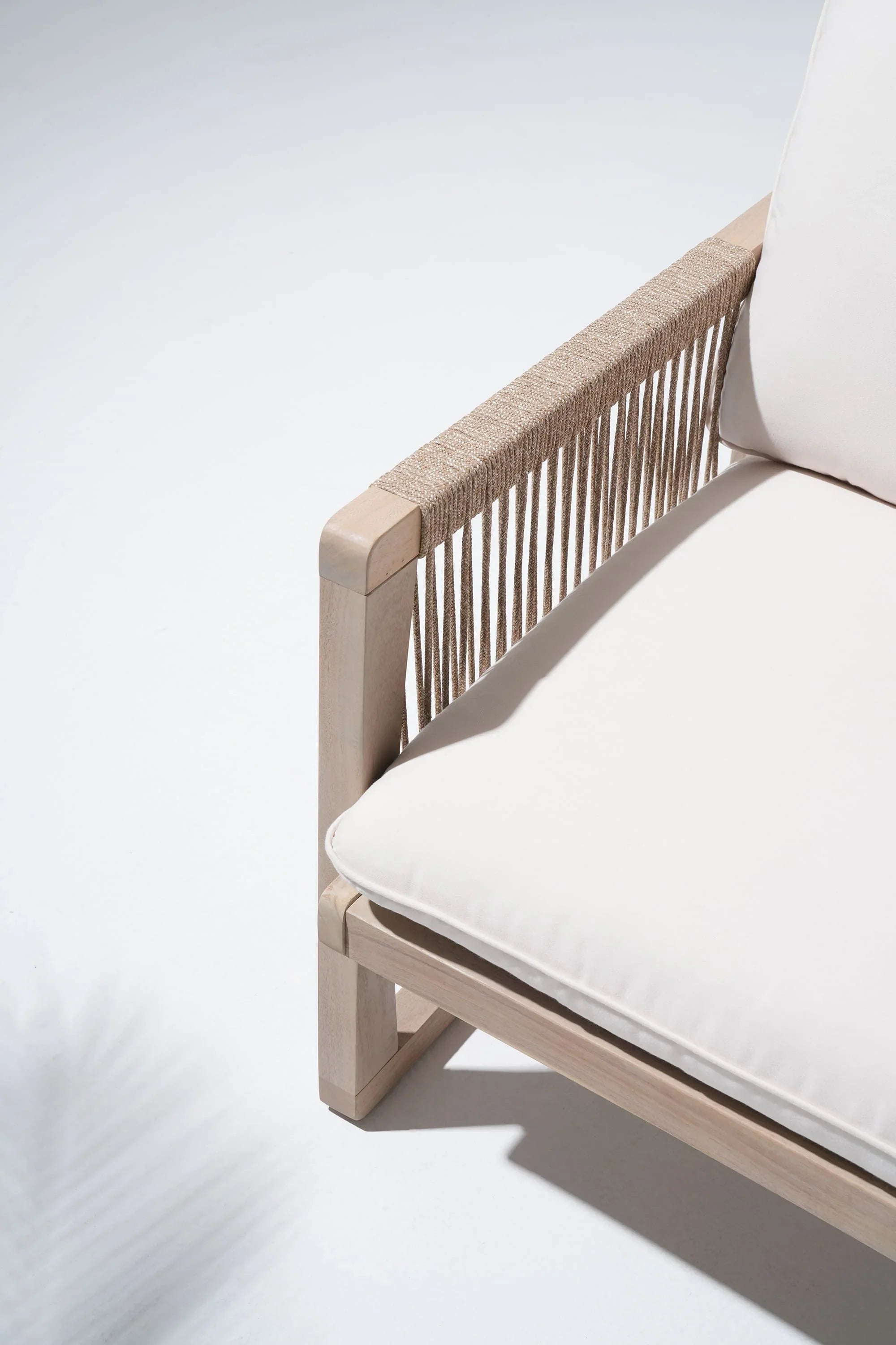 Wooden chair with white cushions, woven rope armrest