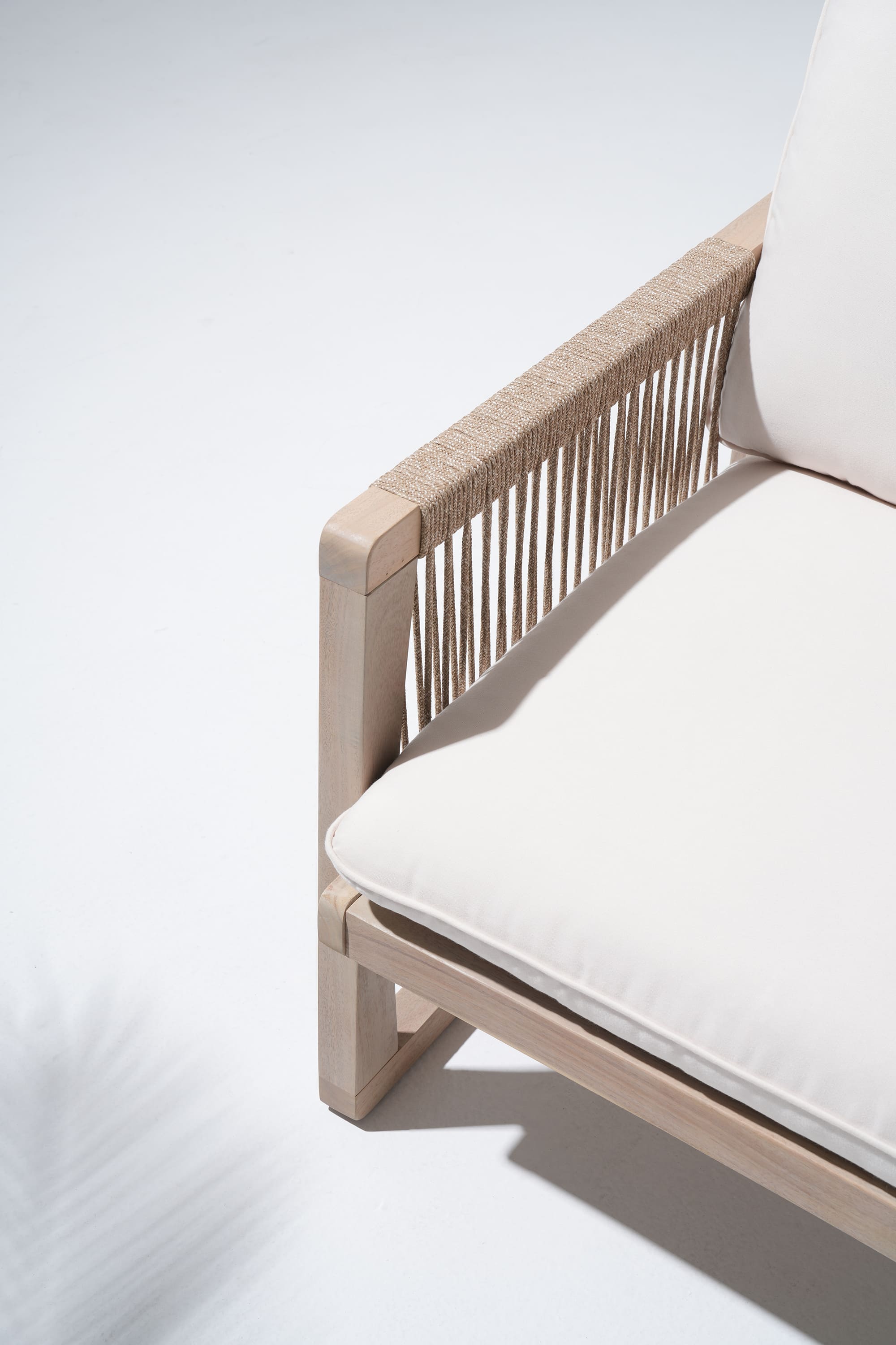 Wooden chair with white cushions, woven rope armrest