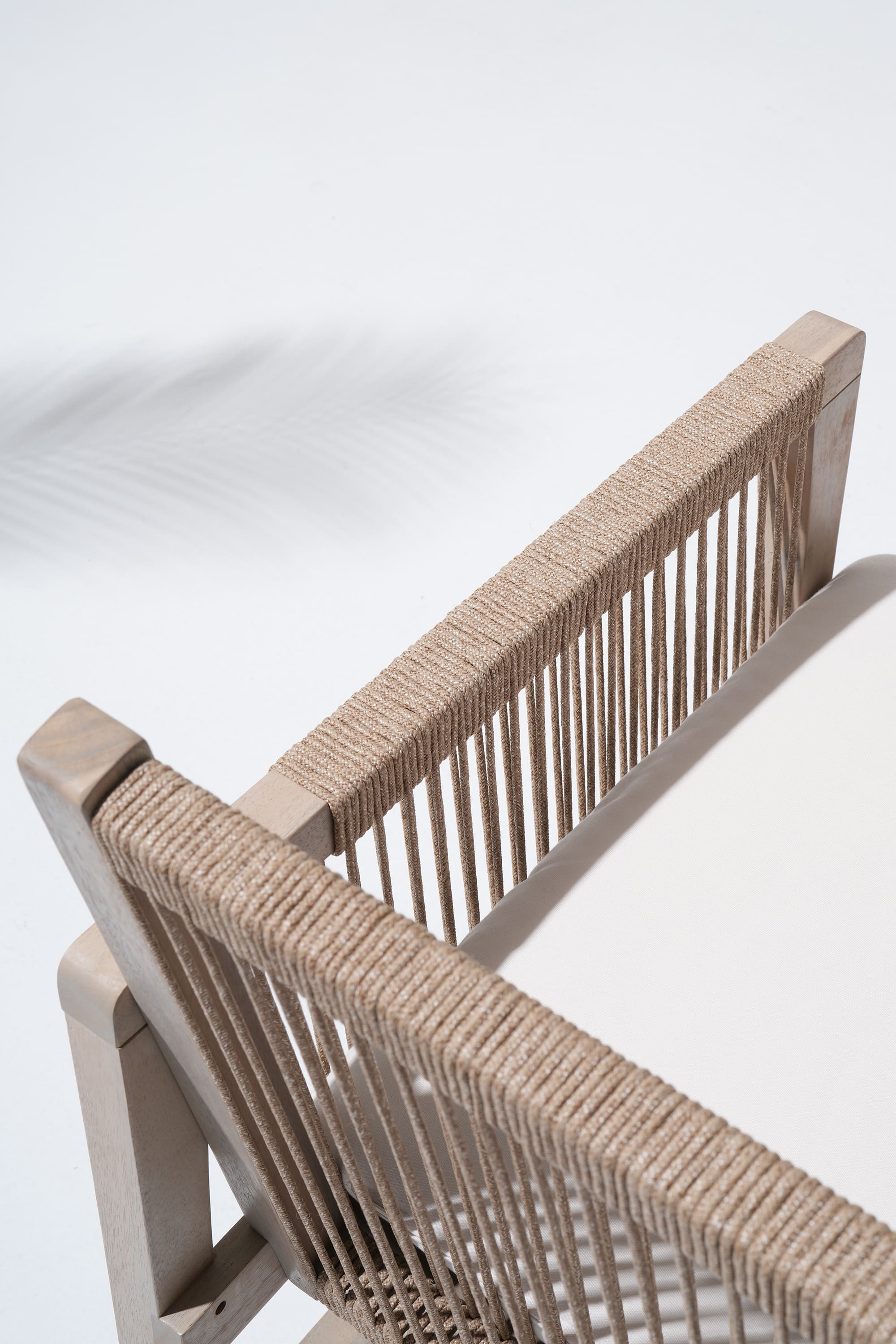 Close-up of a woven chair, rope design backrest and armrest