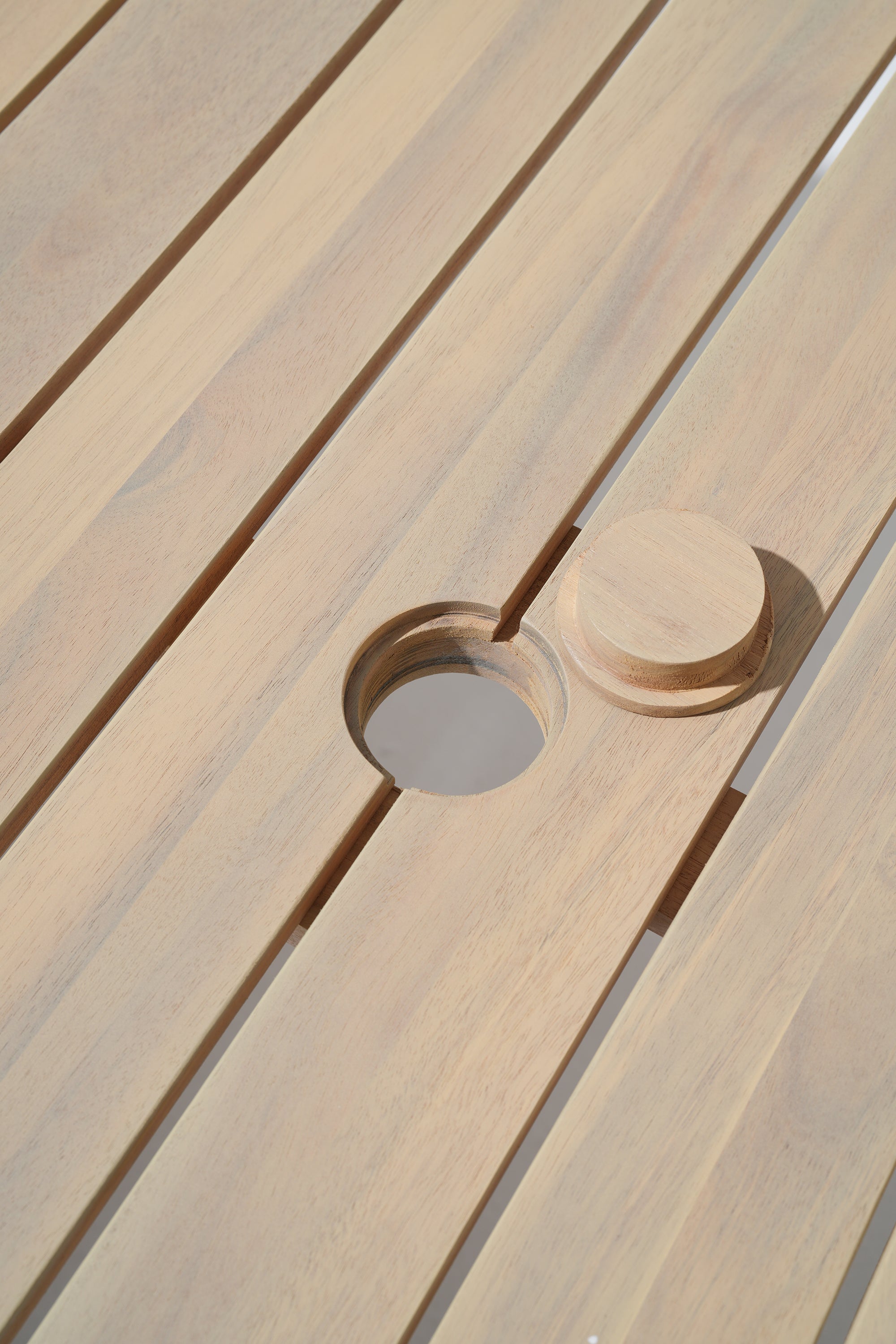 Close-up of a acacia wooden table with a circular umbrella hole