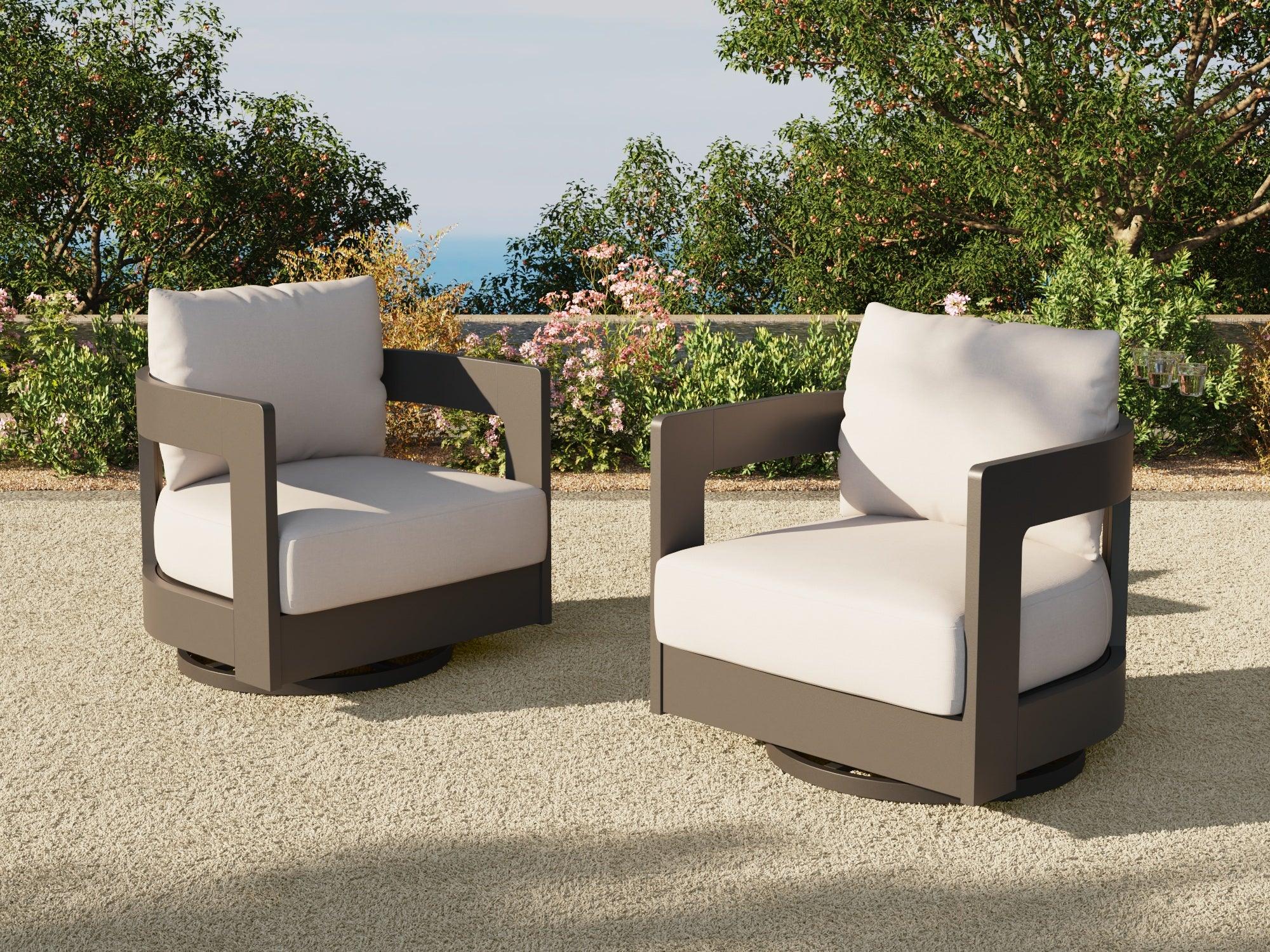 Two outdoor swivel chairs with white cushions