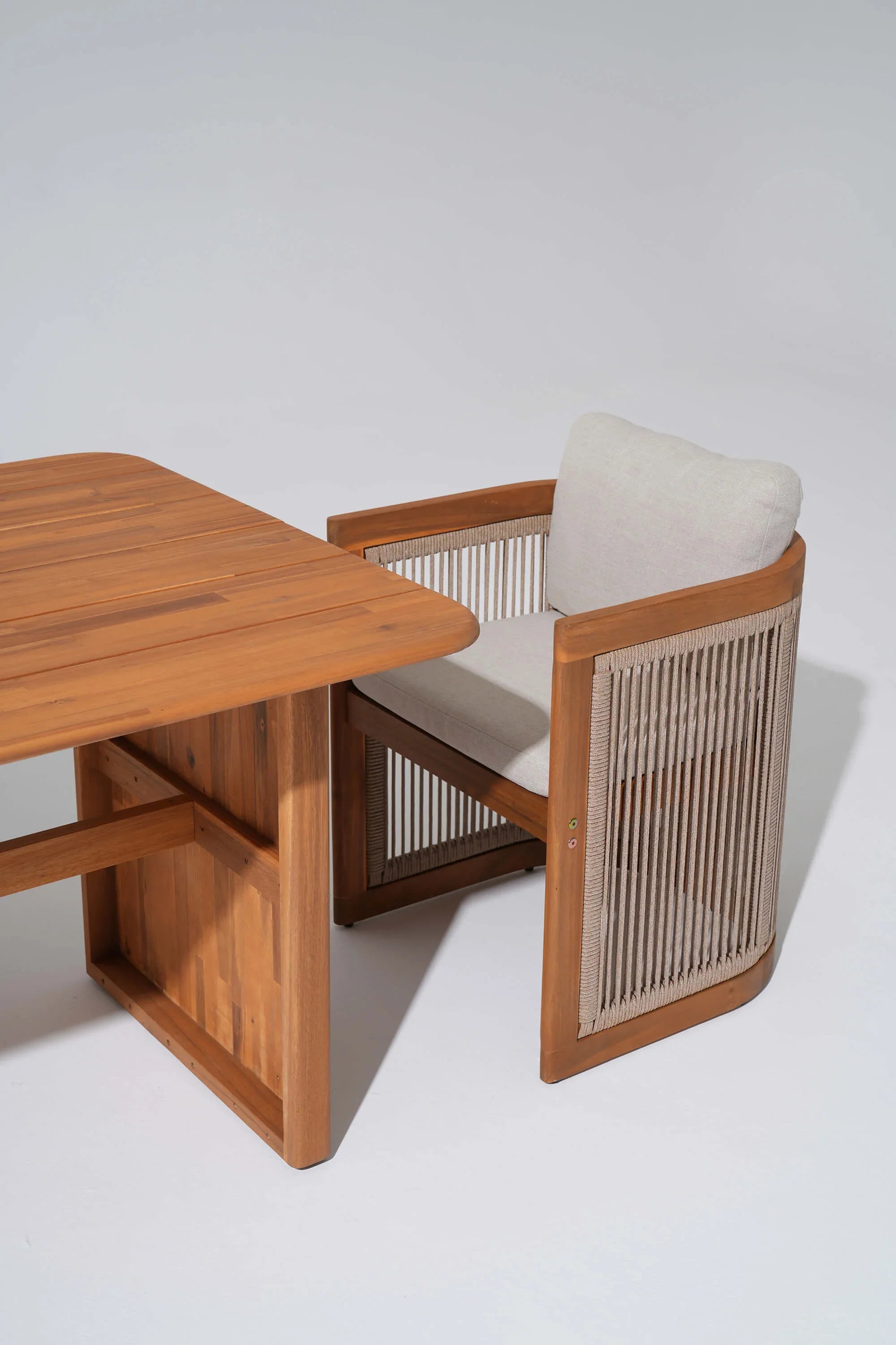 acacia Wooden chair with woven rope backrest next to a wooden table- Jardina Modern Premium Patio Outdoor Furniture