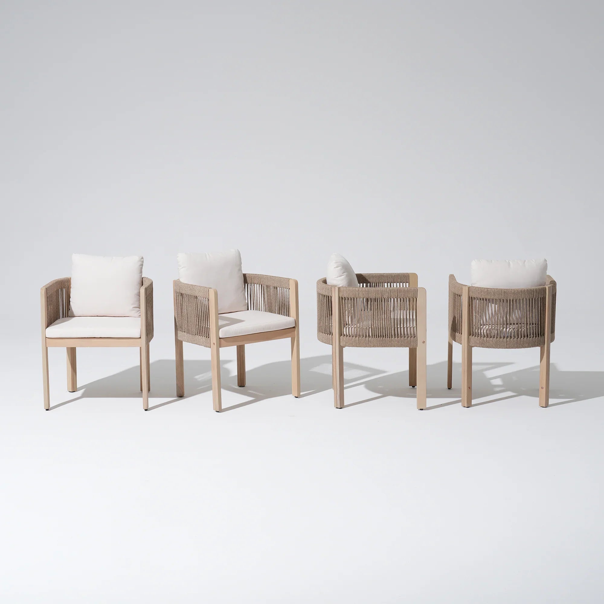 Four wooden patio dining chairs with woven armrests and white cushions- Jardina Modern Premium Outdoor Patio Furniture