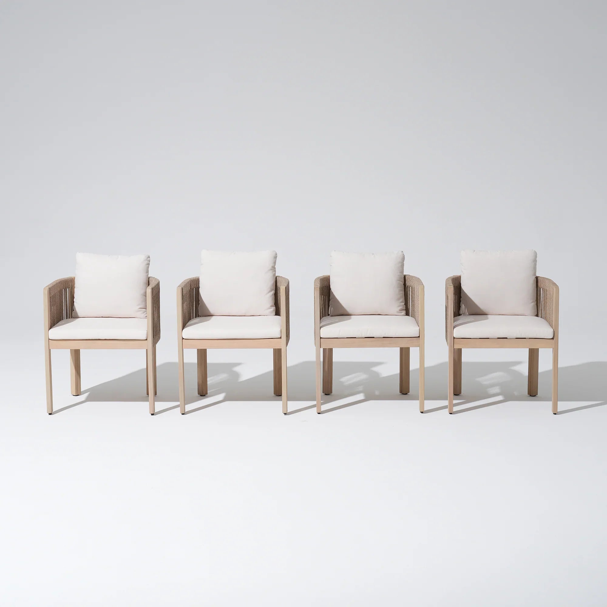 Four acacia wooden dining chairs with white cushions, front angle- Jardina Modern Premium Outdoor Patio Furniture