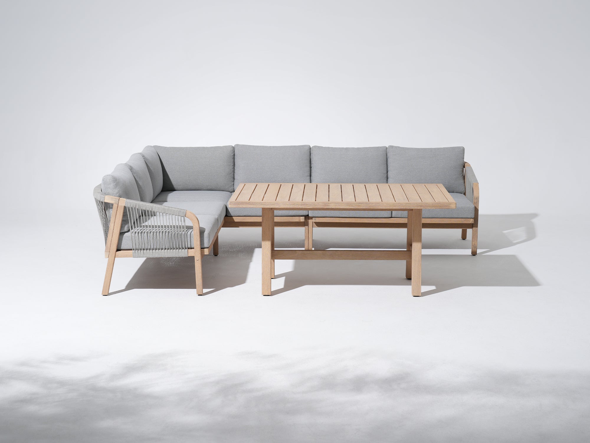 Outdoor furniture conversation set with a L-shaped sectional sofa and wooden dining table