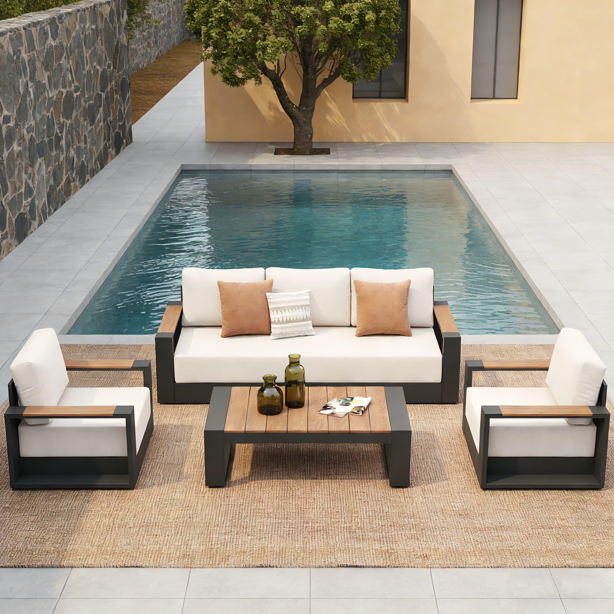 Outdoor patio set with sofa, chairs, and table by a pool
