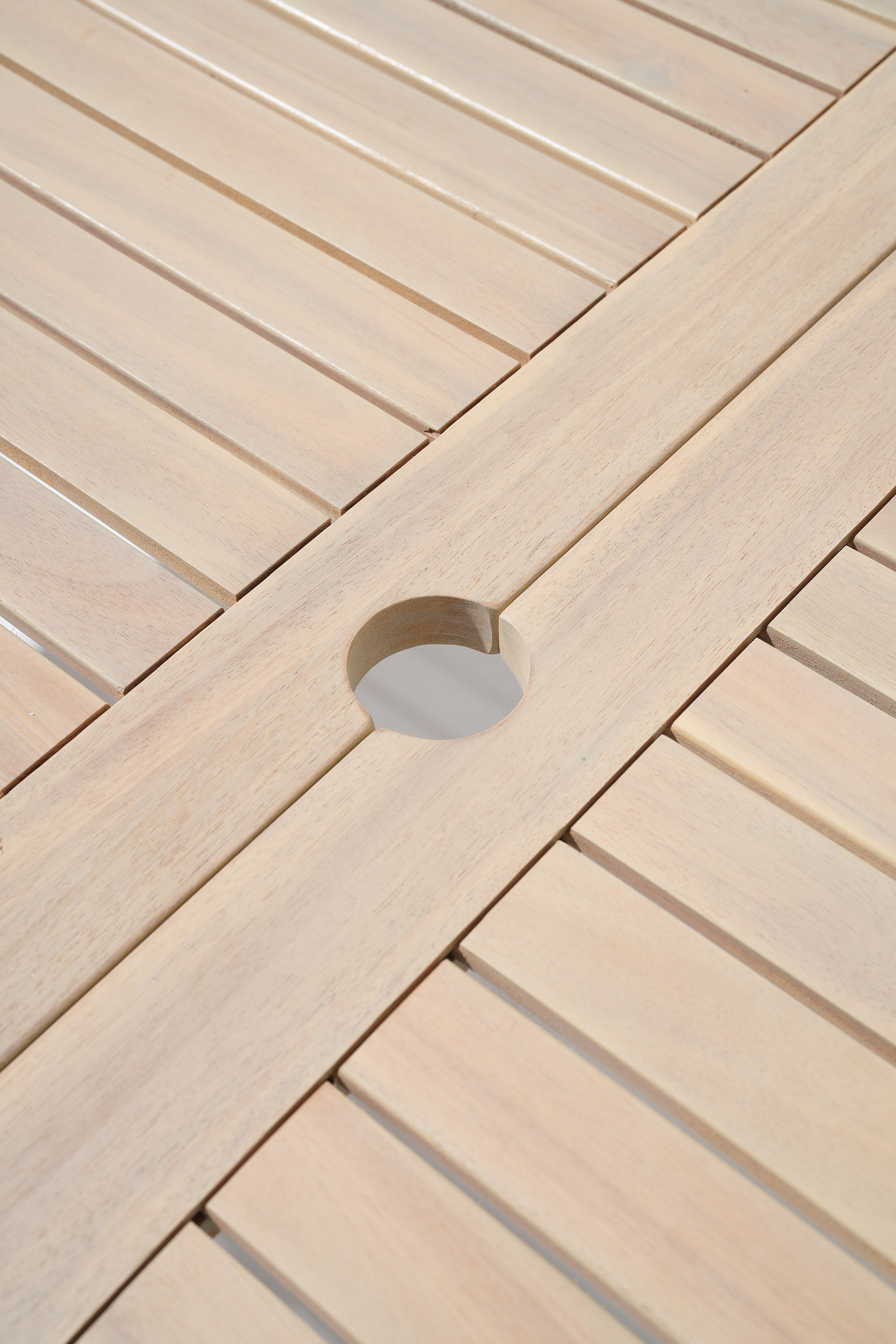 Close-up of acacia wooden table with a circular umbrella hole