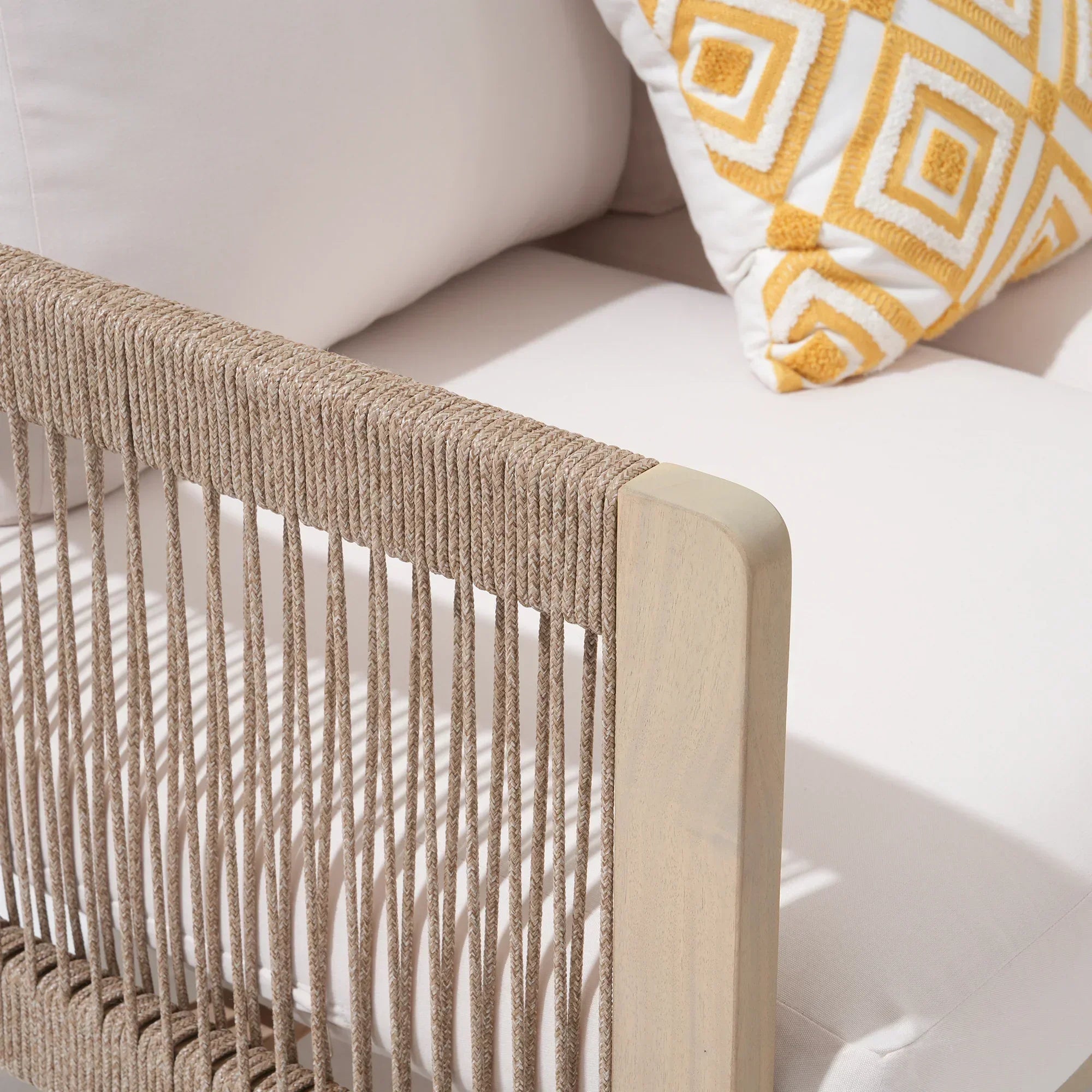 Close-up of a beige sofa with woven armrest