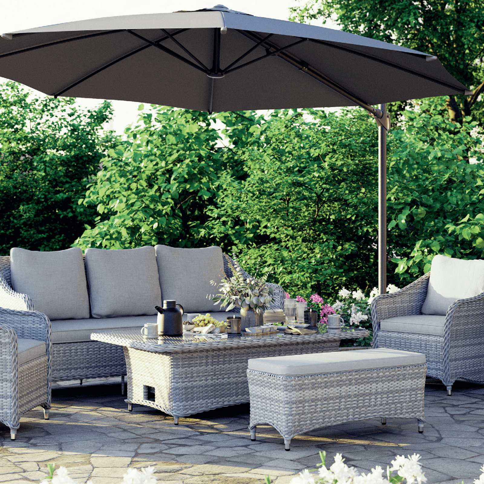 Irati 5-Piece grey wicker outdoor seating set with aluminum frame, light grey cushions, 1 three-seater sofa, 2 armchairs, 1 bench, 1 lift top dining table, under a round offsite umbrella- Jardina Furniture