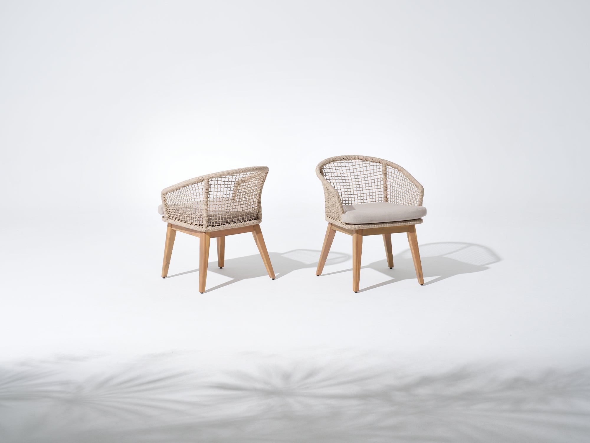 Two wooden chairs with woven backrests and cushioned seats