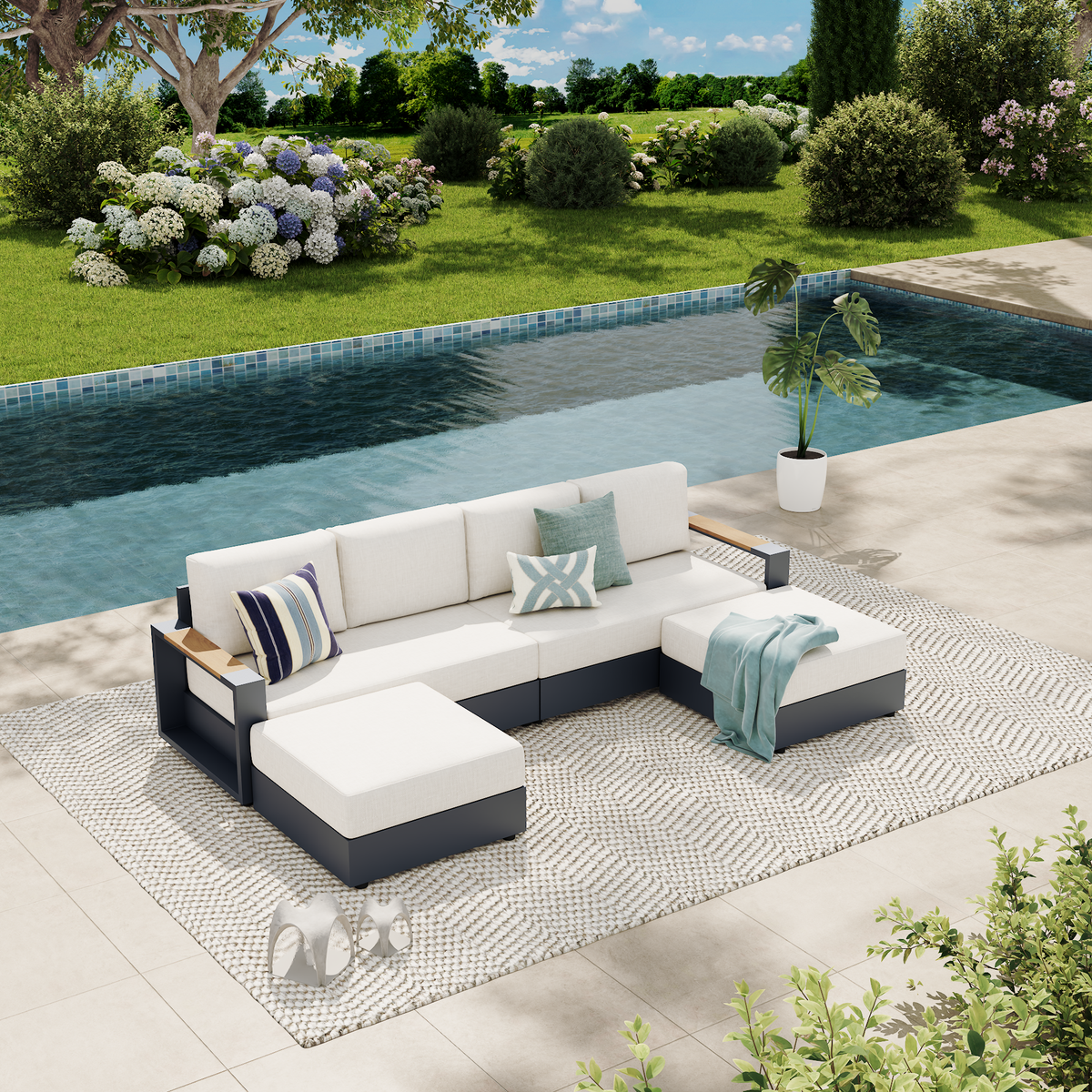 An outdoor sectional patio sofa set with white cushions and a dark gray frame, styled on a patterned rug beside a swimming pool in a landscaped garden setting. #config_U‑Shape with Chaise