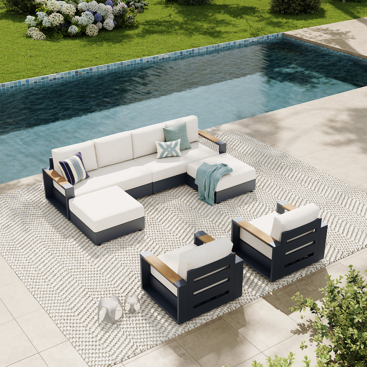 Outdoor patio conversation set with a sectional sofa, two armchairs, and a small round coffee table on a patterned rug beside a swimming pool. #config_U‑Sofa + 2 Swivels