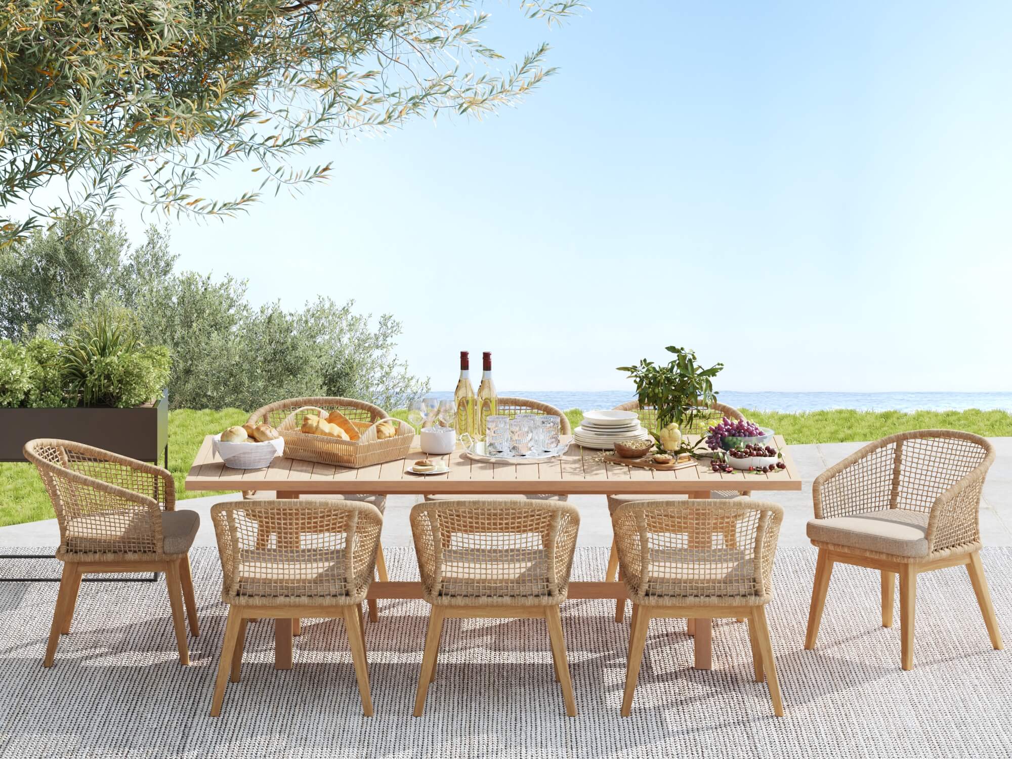 wooden Outdoor dining set for 8 with rope chairs and table, set for a meal with wine and food, on a patio with greenery and ocean view- Jardina Modern Premium Patio Outdoor Furniture