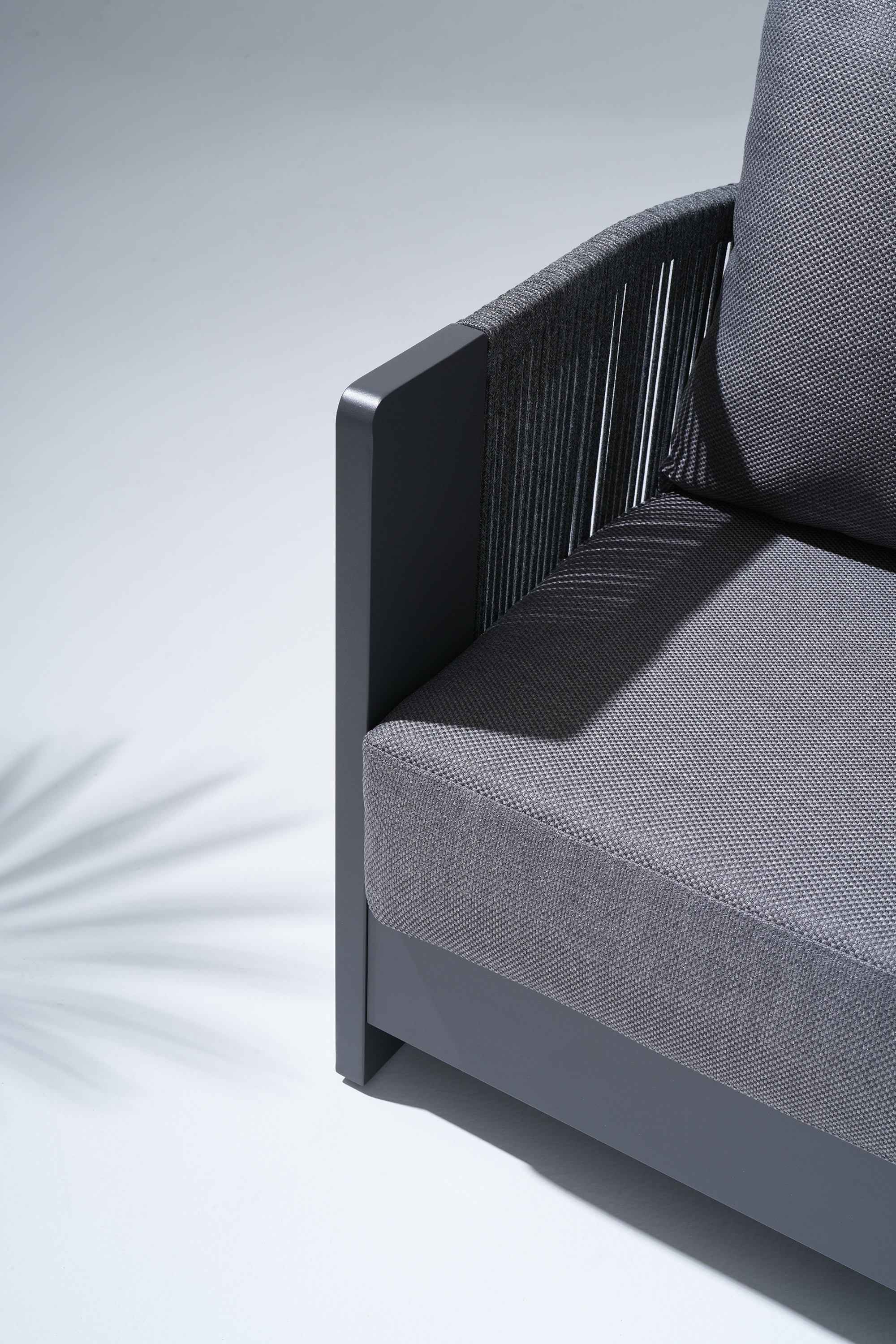 Gray cushioned chair with dark grey woven backrest