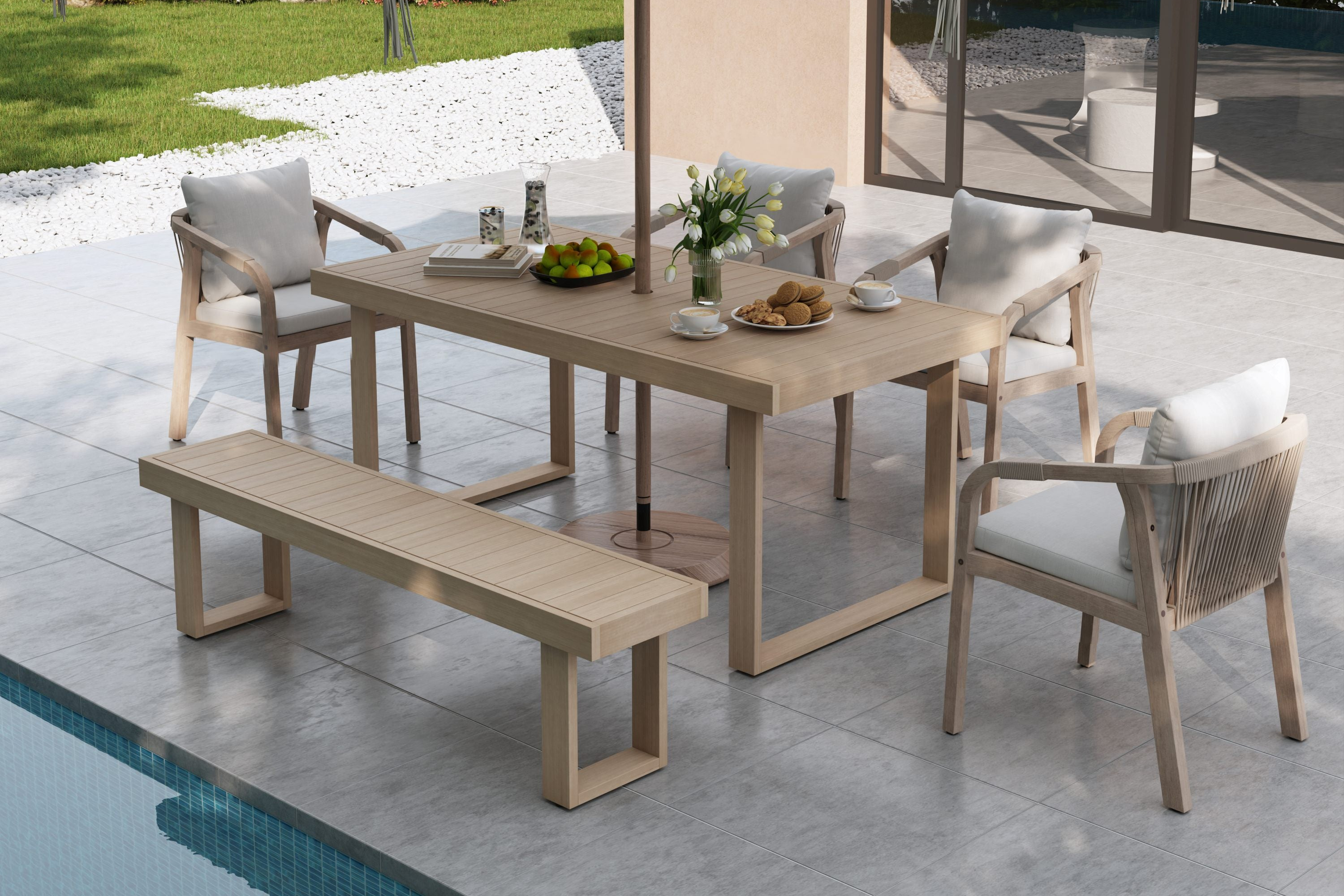 Outdoor dining set with table, chairs, and bench by a poolside.
